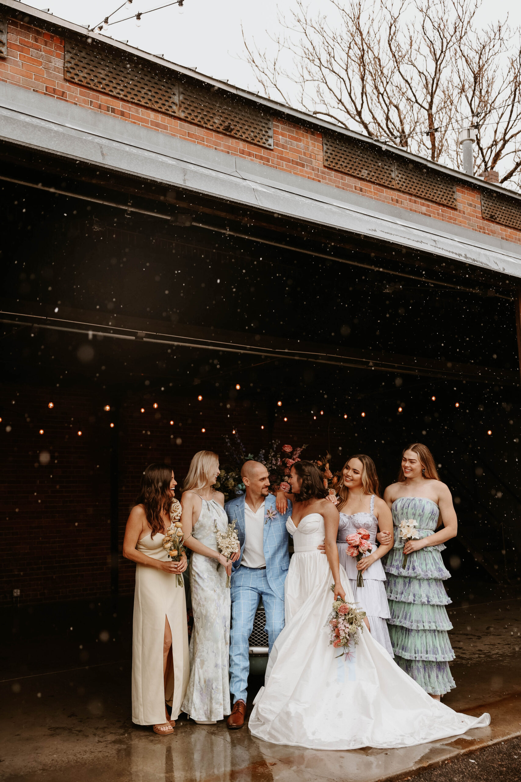 bridal party portraits with snow during a colorful spring wedding 