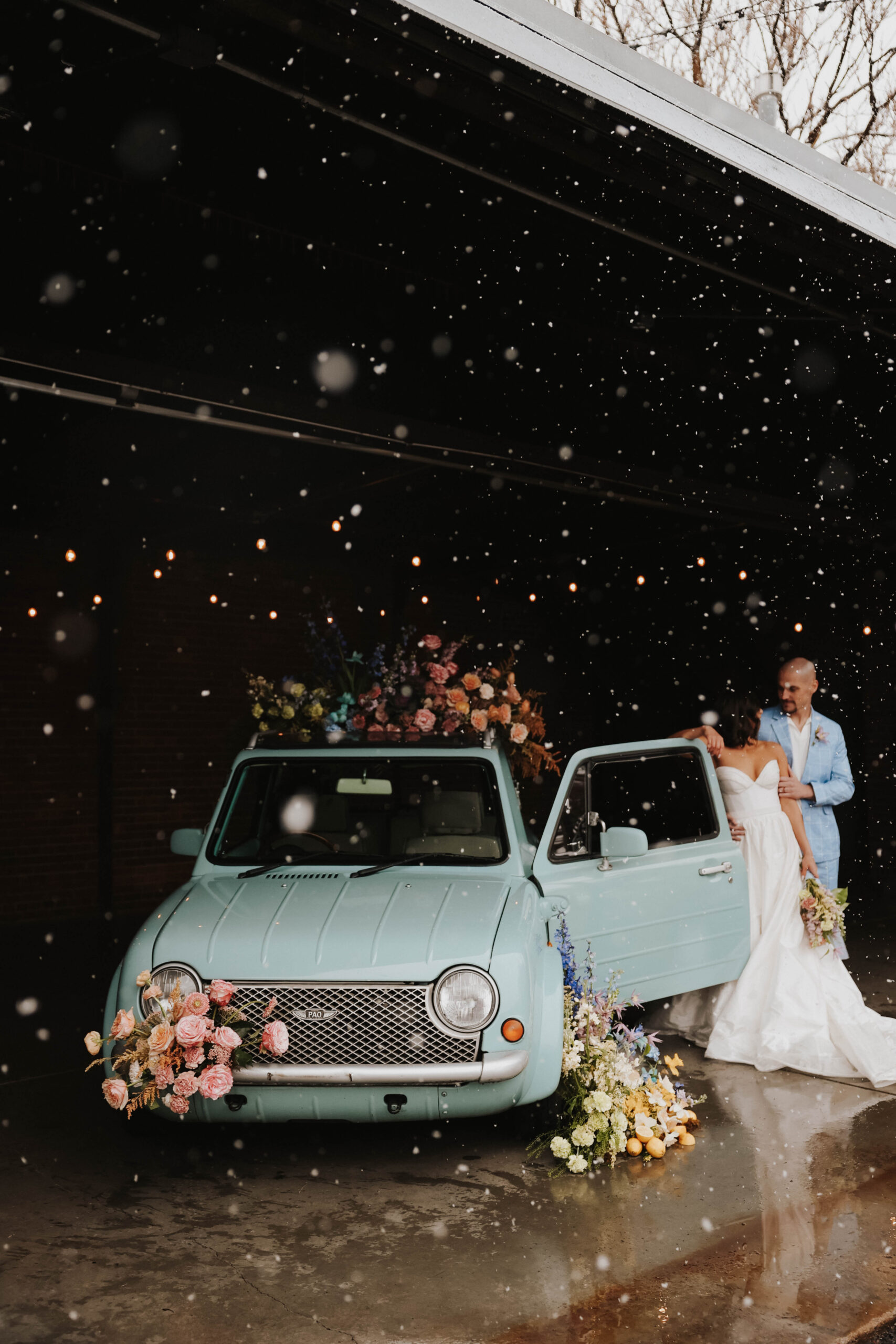 bride and groom standing at the door of the car during a colorful spring wedding 