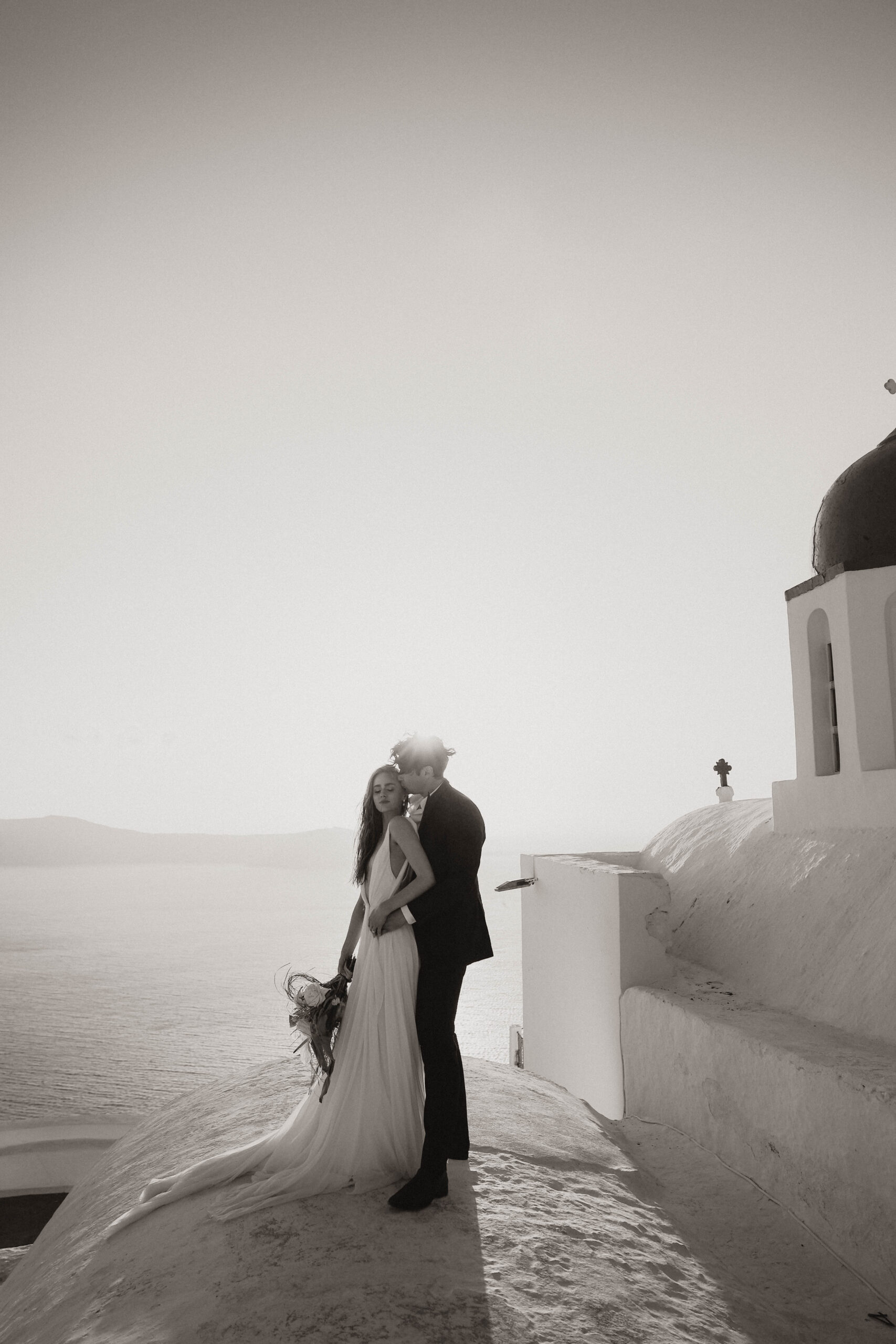 bride and groom on a roof in santorini during their elopement 