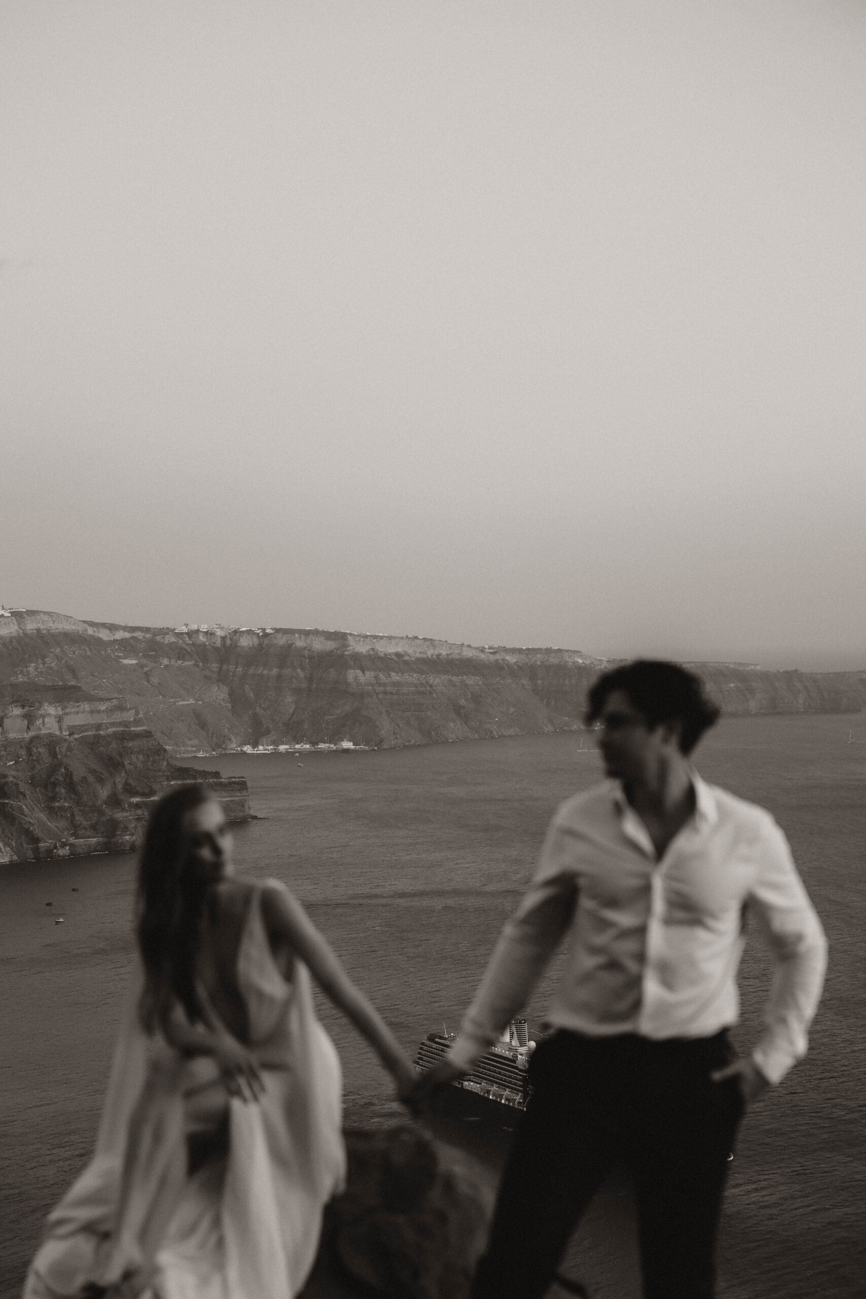 bride and groom blurred with the cliff and ocean behind them 