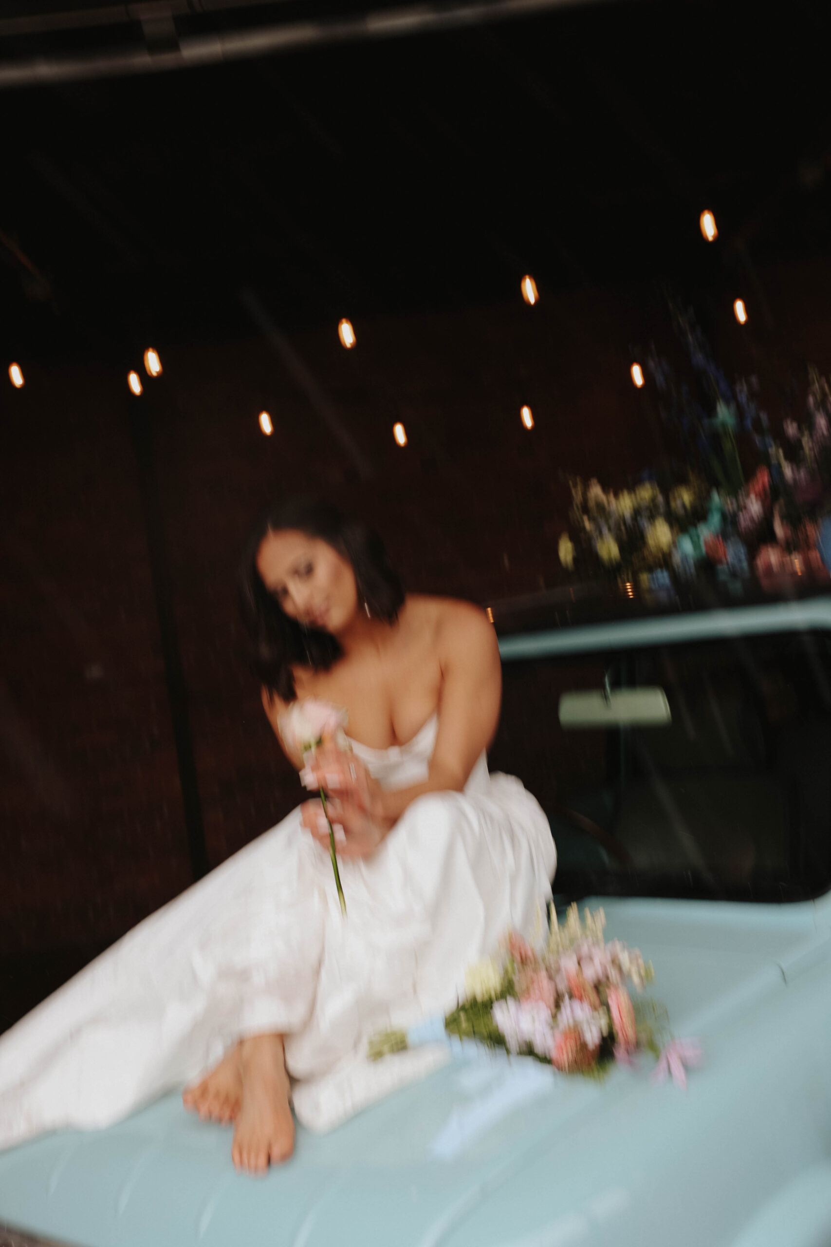 barefoot bride sitting on the hood on the car