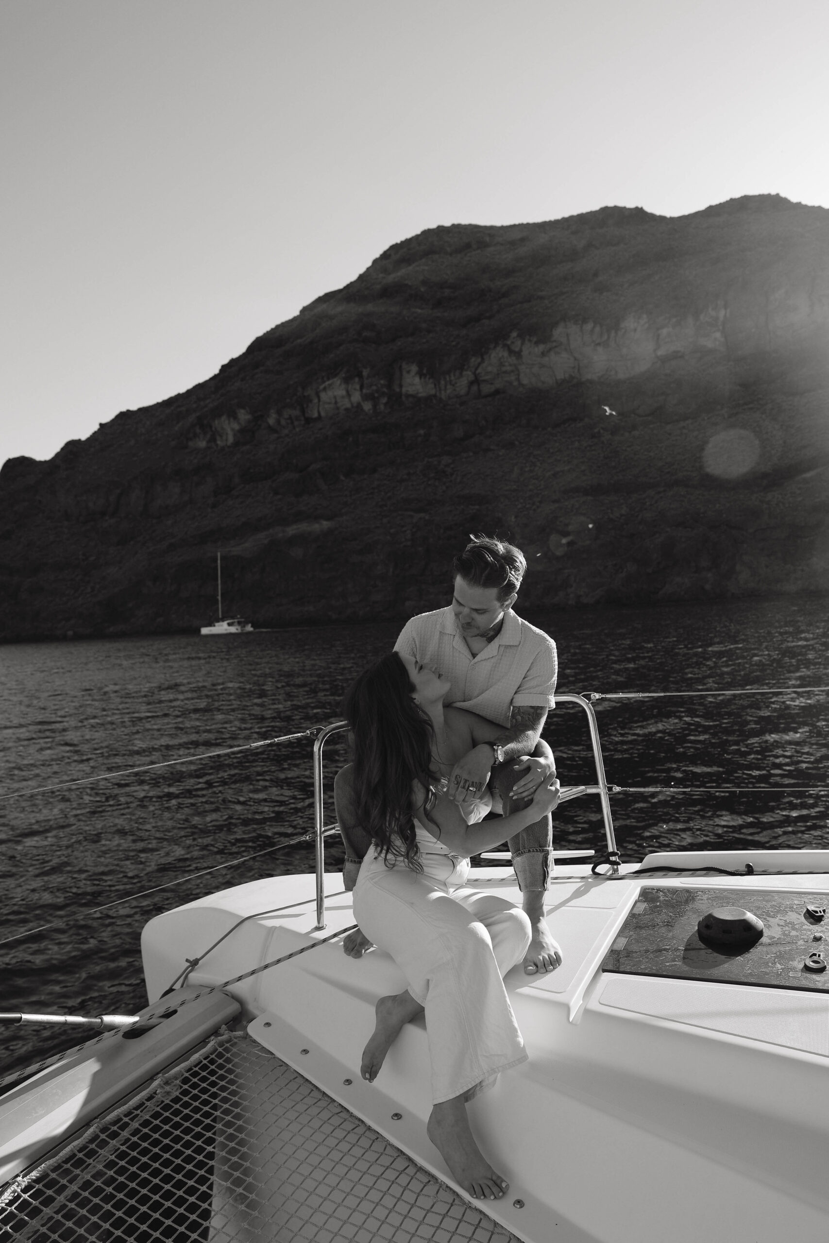 a couple sitting on a sailboat looking at each other during their couples session