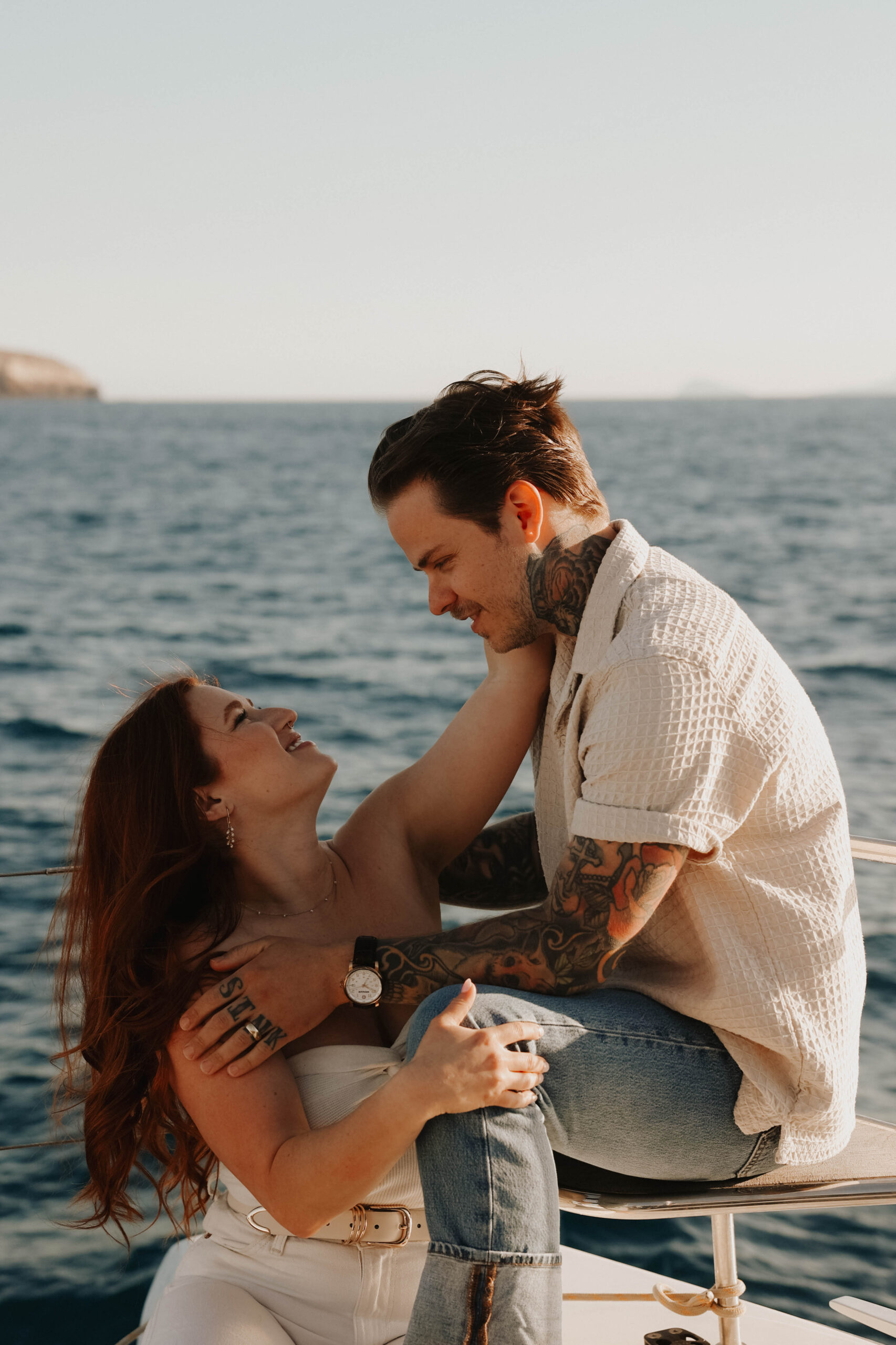 a couple holding each other on a sailboat in Greece 