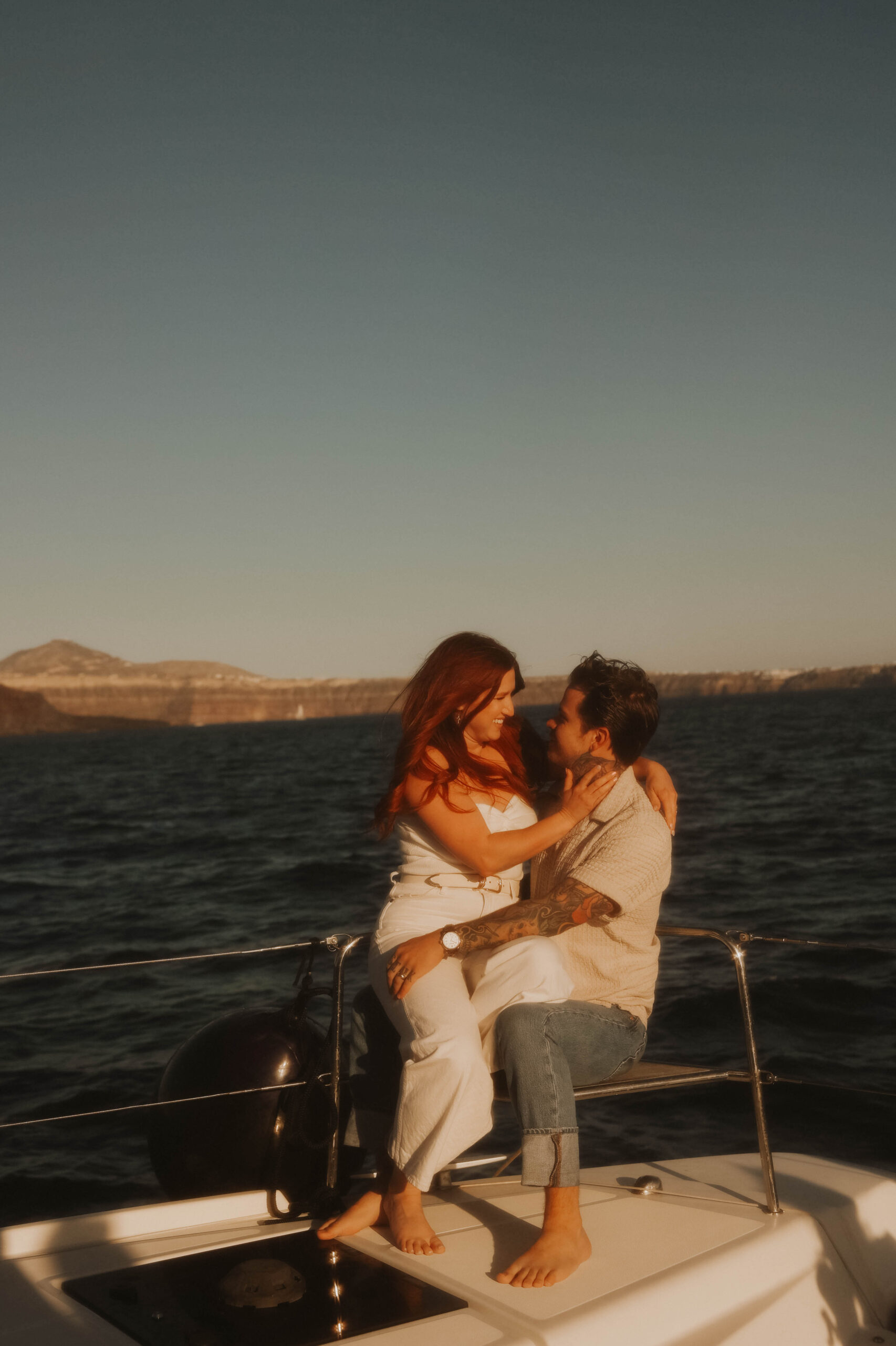 a couple sitting on a sailboat together during their couples session