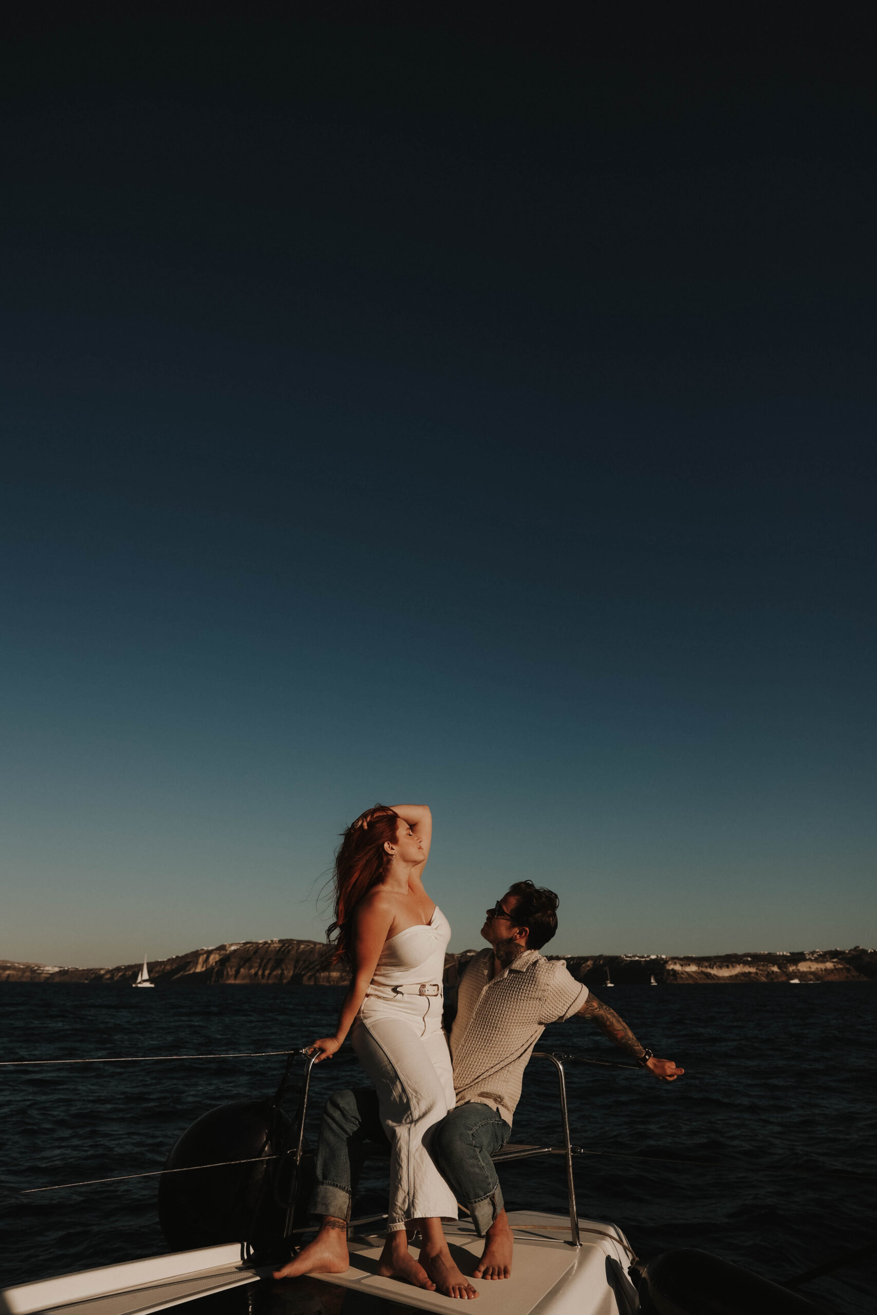 a couple on a sailboat in the wind during their couples session