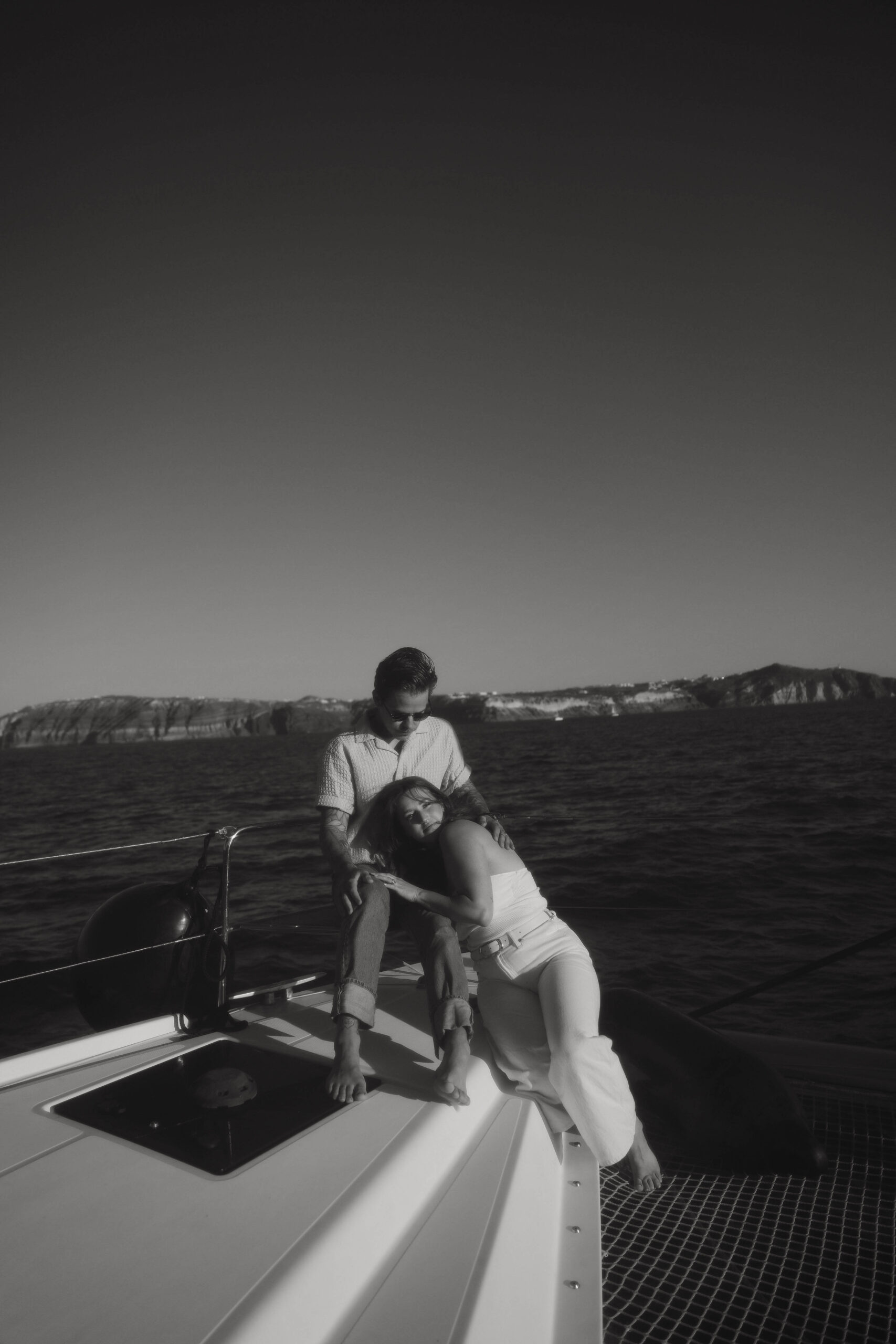 a couple sitting on a boat in Greece during their couples session