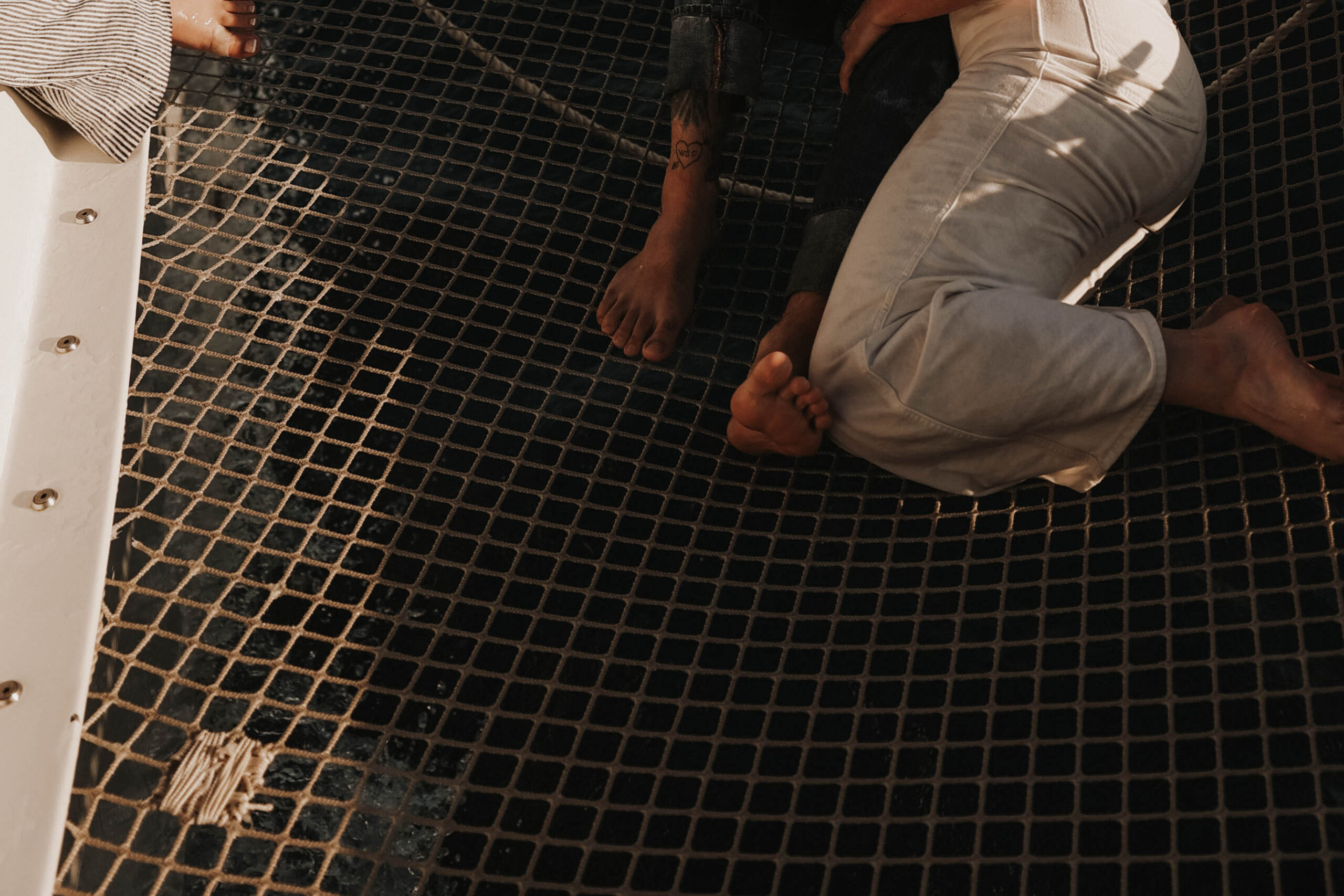 a couple's legs as they lay together on a boat during their couples session