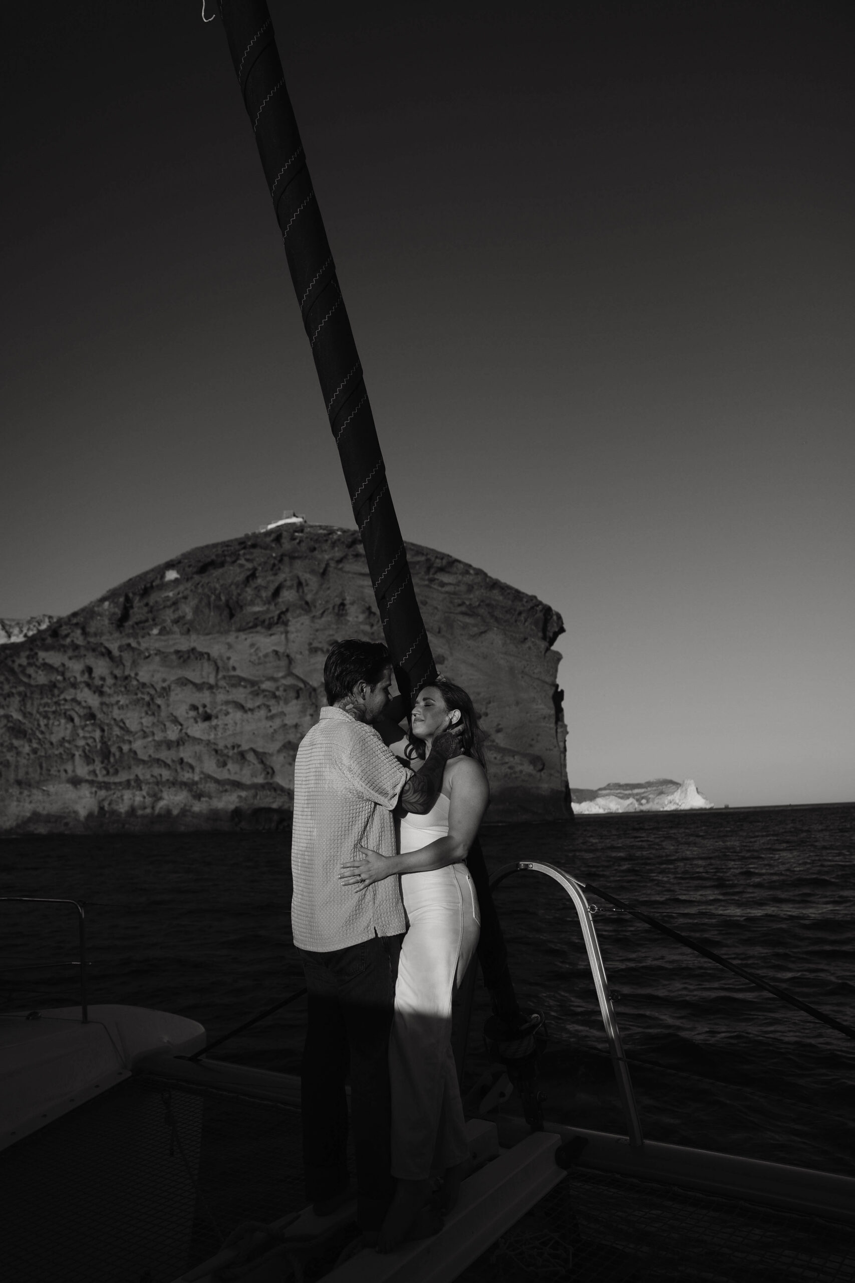 a couple standing on a boat in the shadows during their couples session