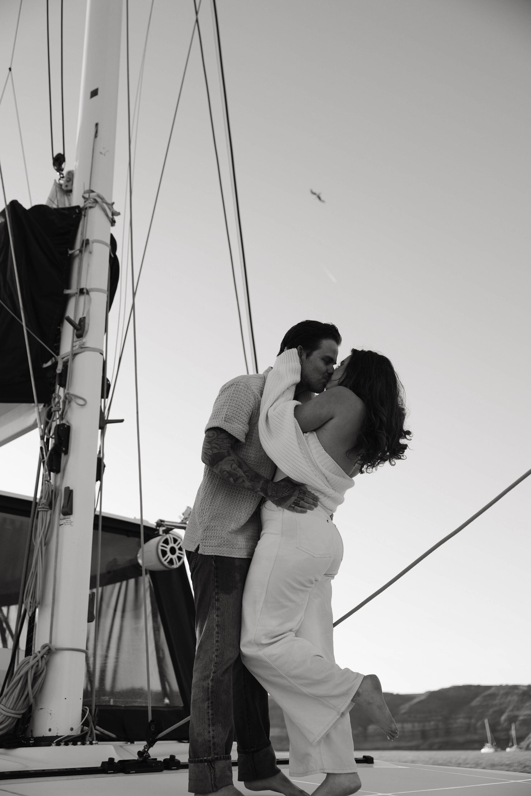 a couple kissing on a sailboat during their couples session