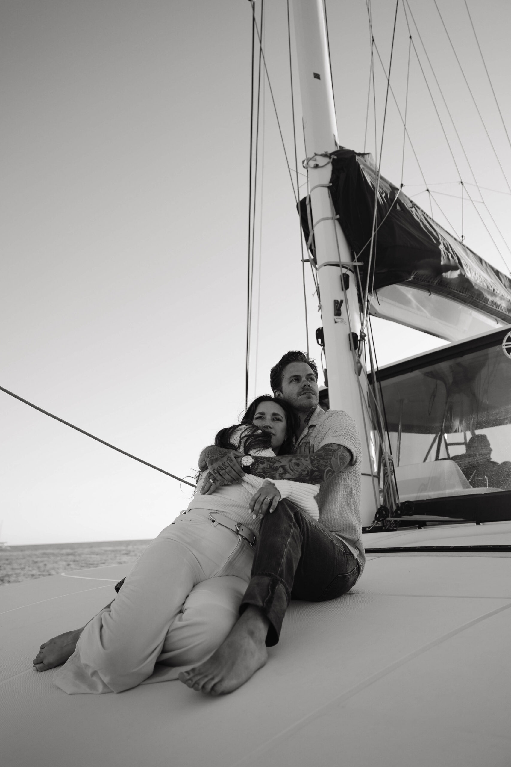 a couple sitting on the front of a sailboat during their couples session