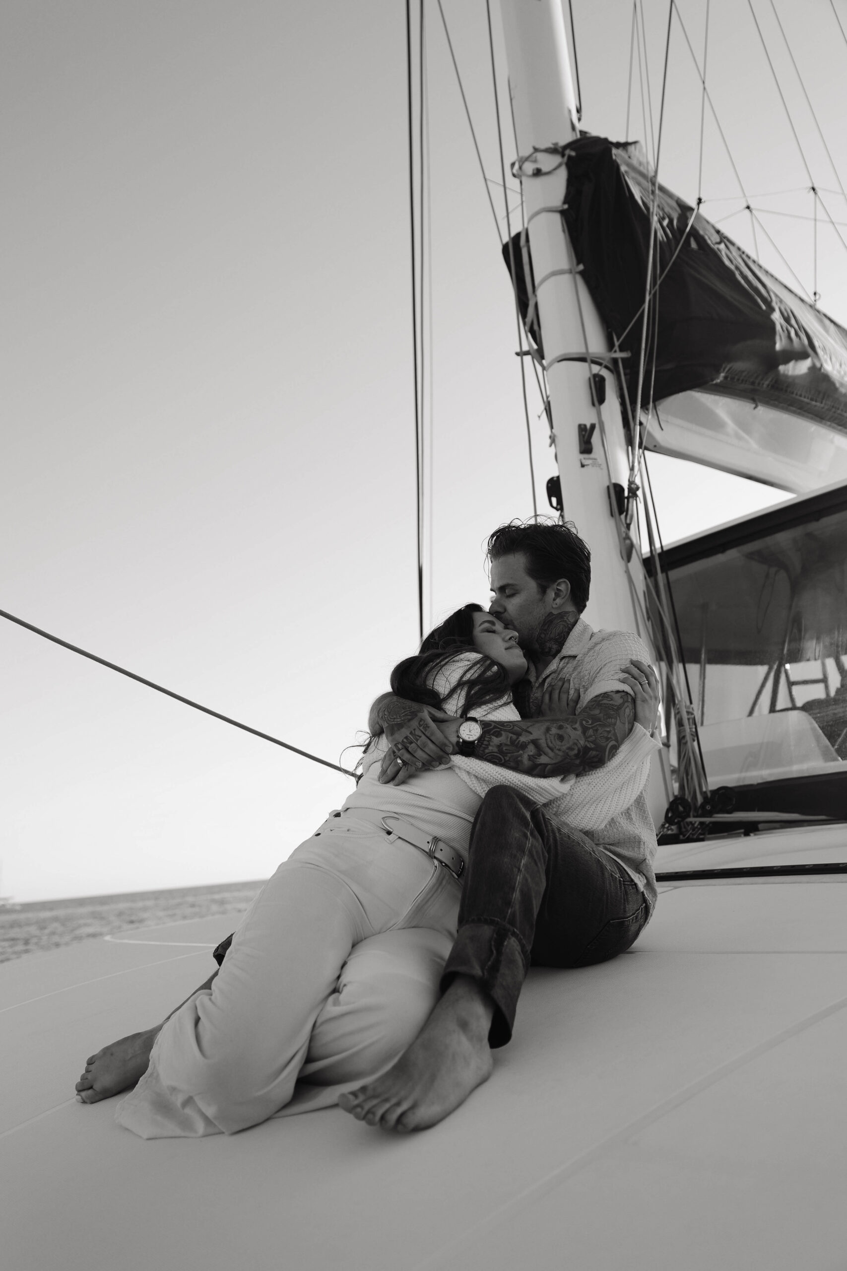 a couple holding each other while sitting on a boat 