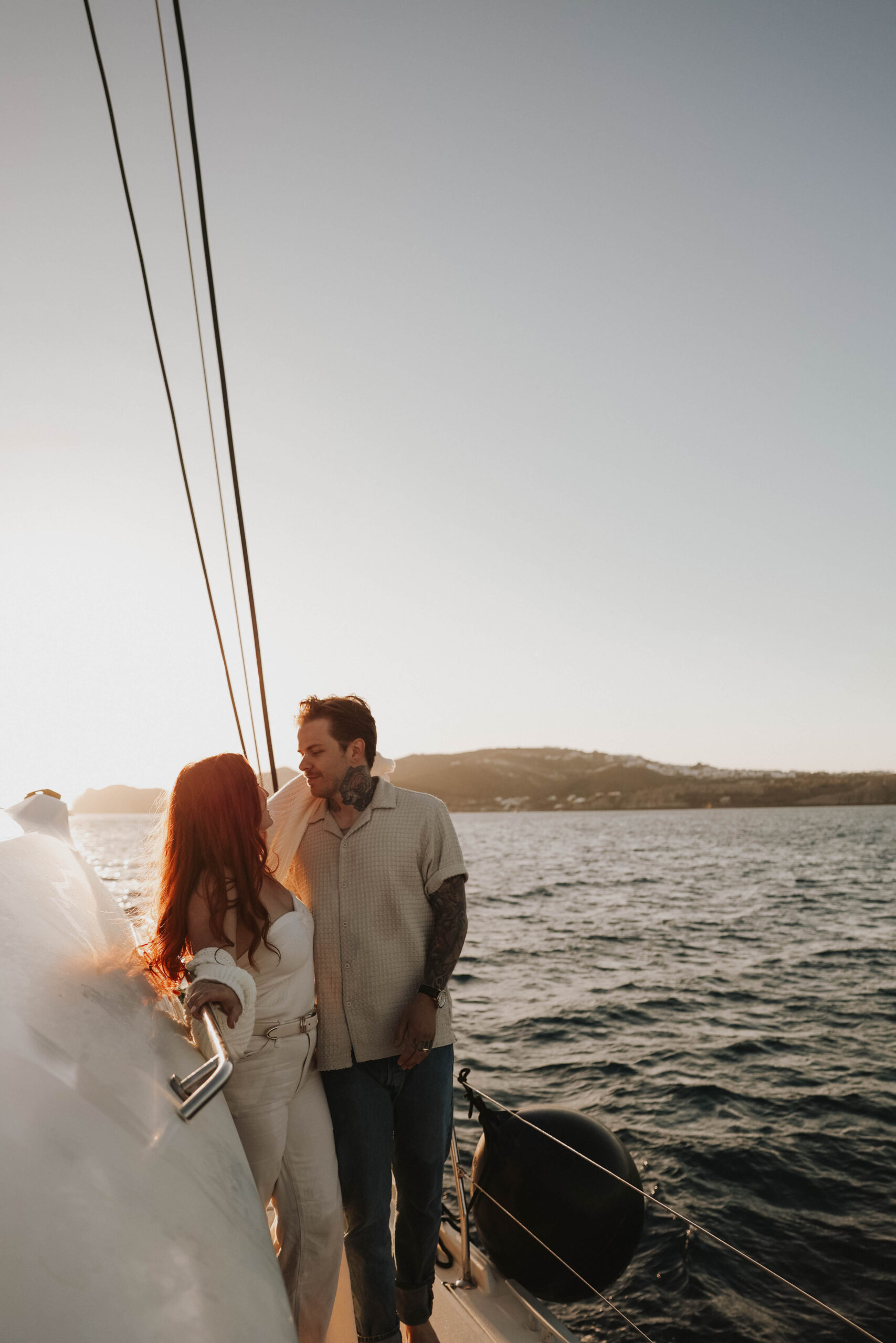 a couple looking at each other while standing on a boat during their couples session