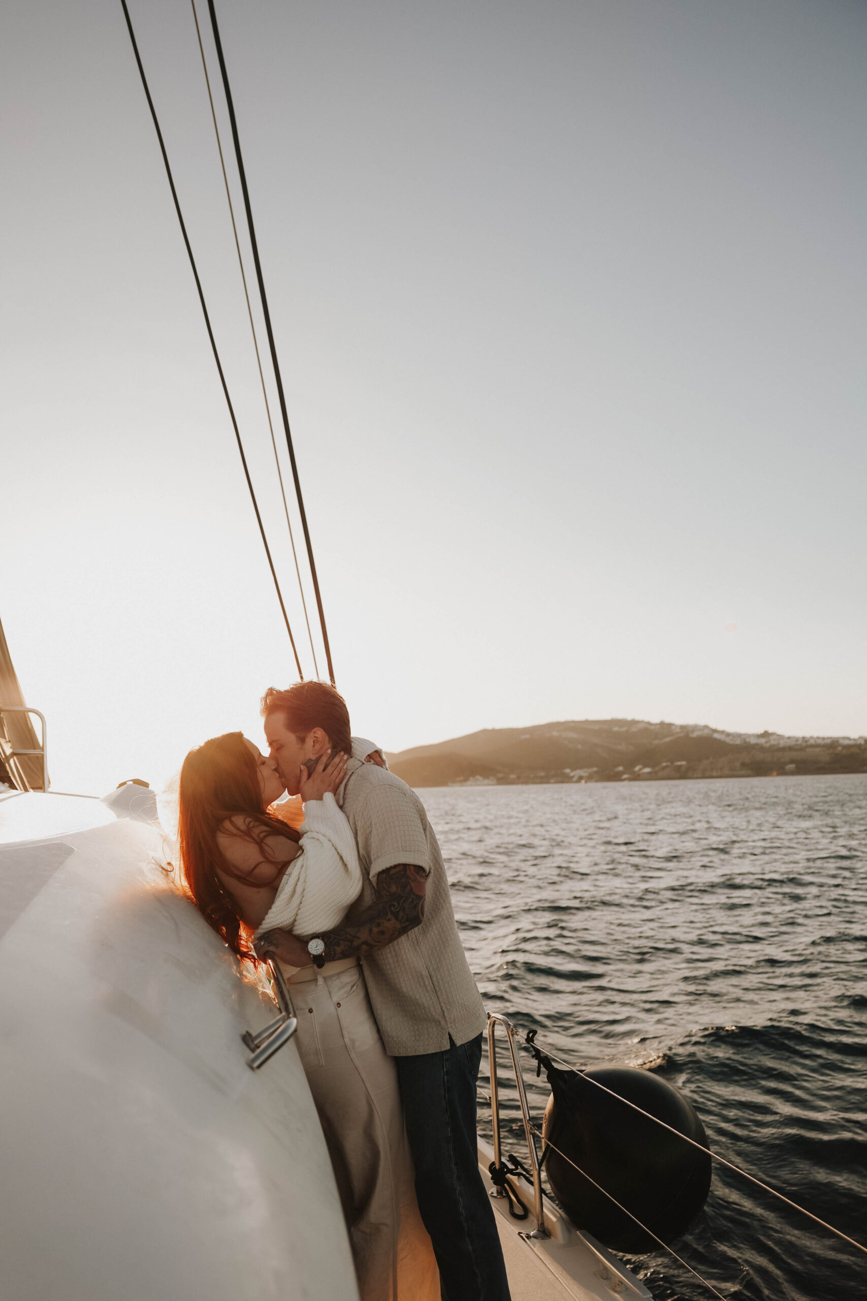 a couple kissing on a sailboat in Greece during their couples session