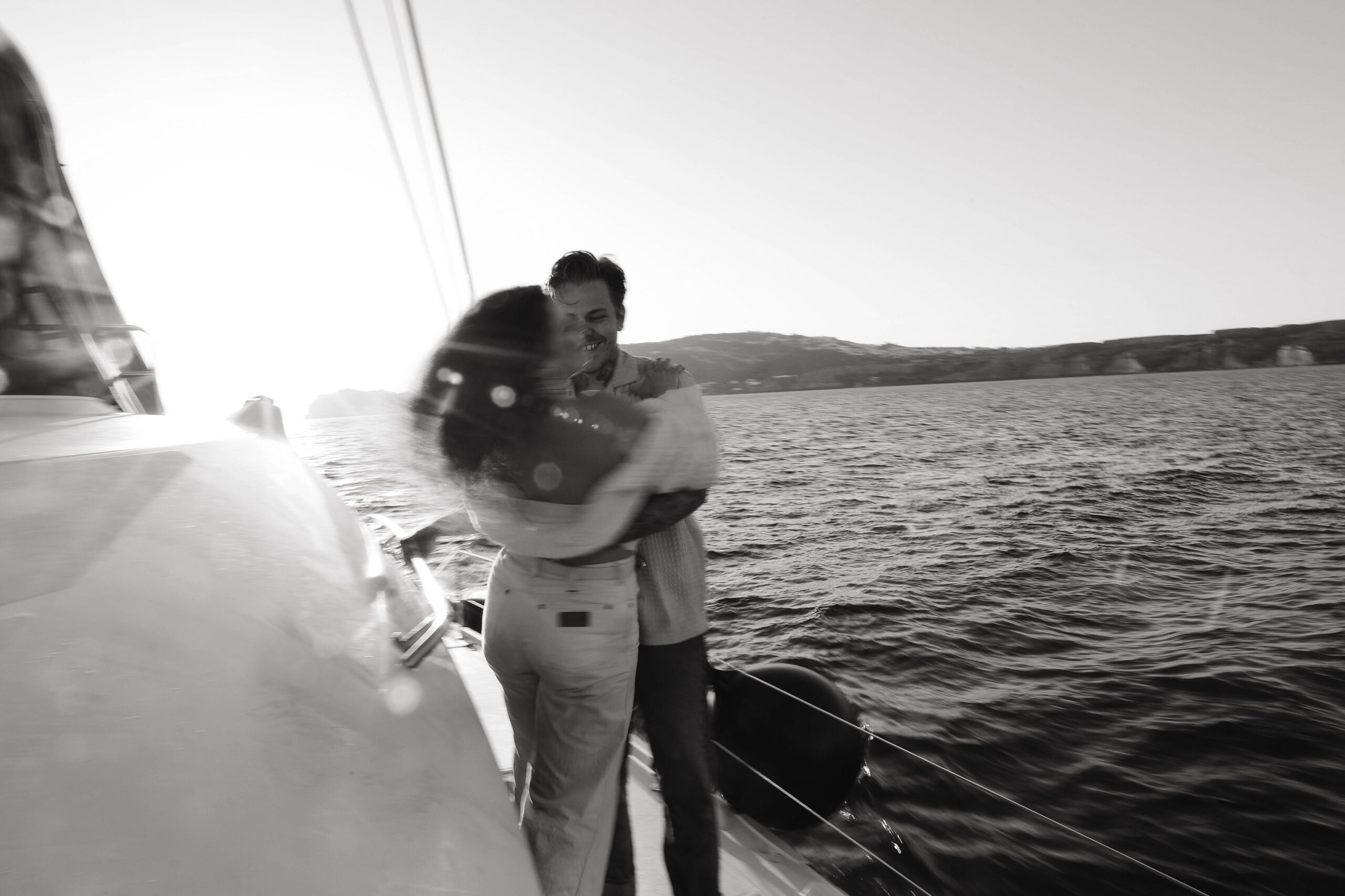 a blurry photo of a couple holding each other on a boat 