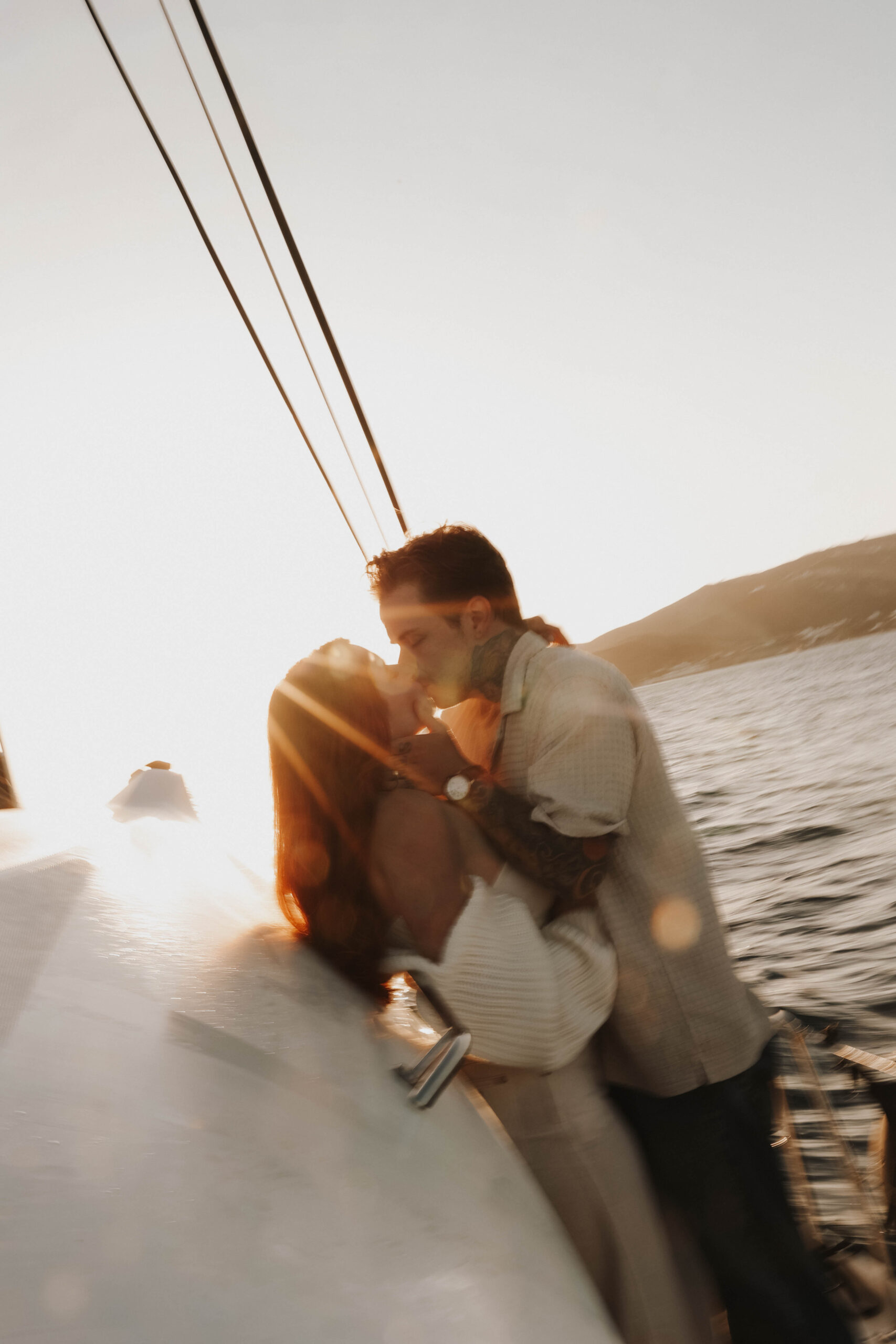 a couple kissing on a sailboat 