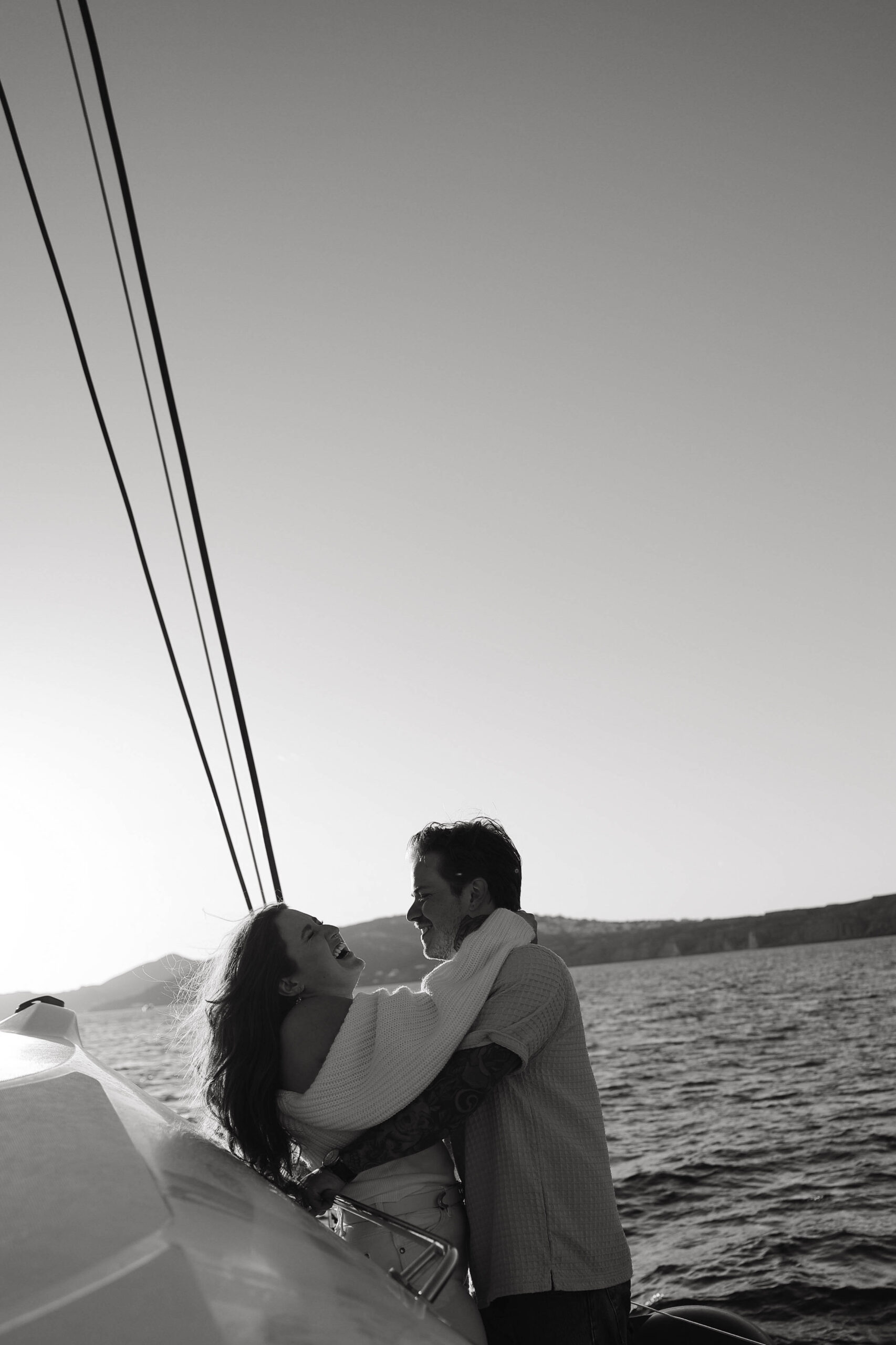 a couple laughing together on a boat in Greece 