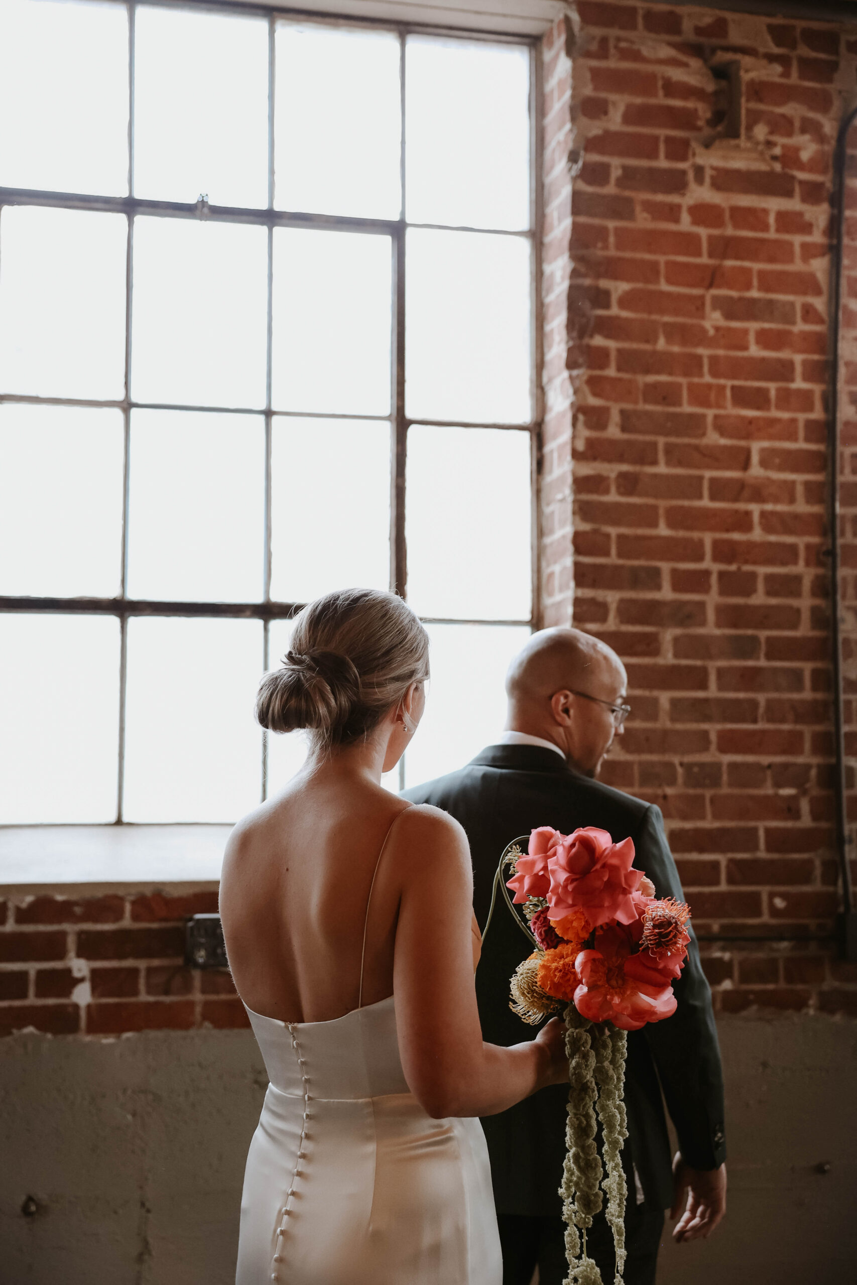 bride tapping groom's shoulder for first look