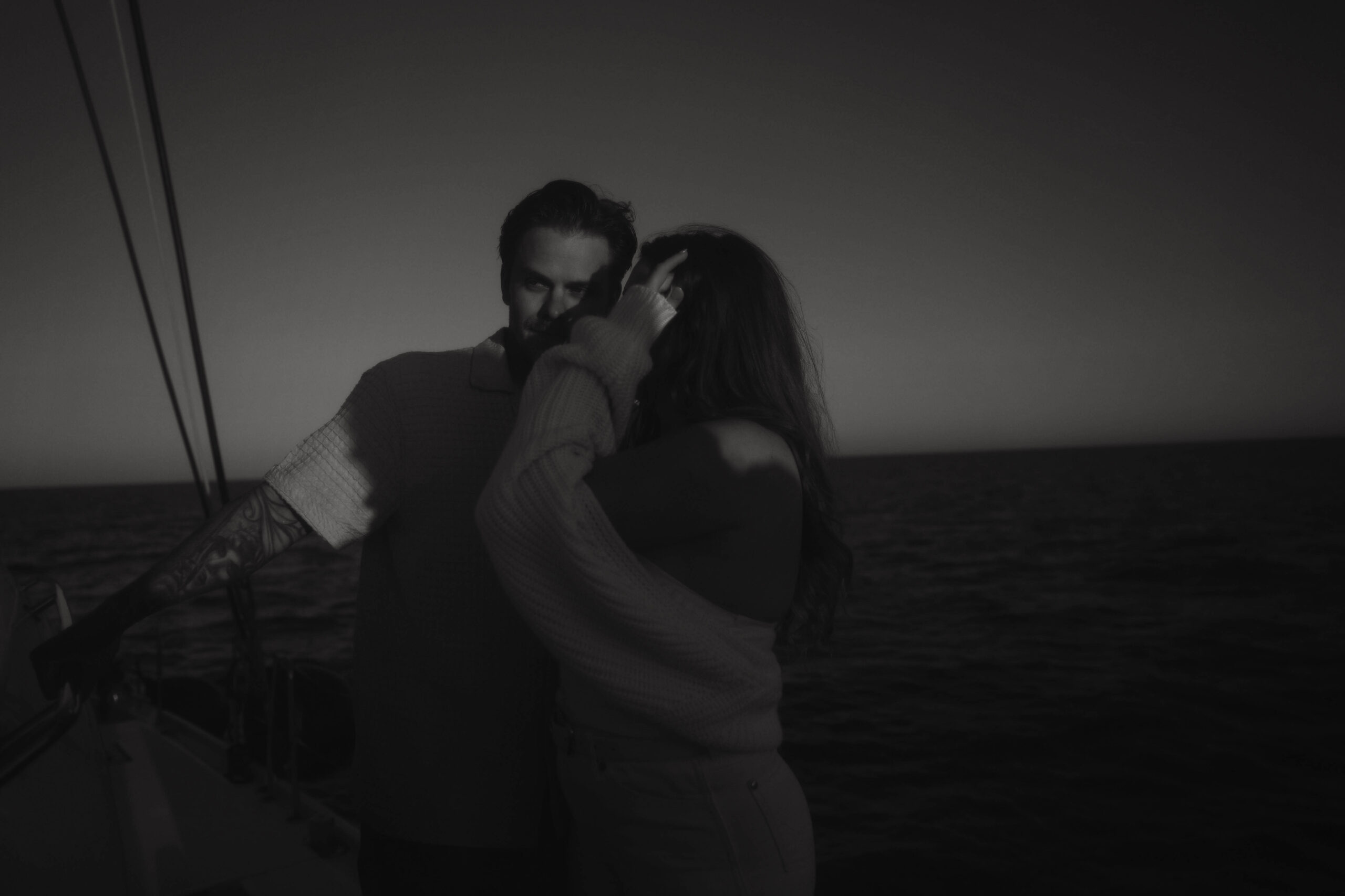 a couple standing close together on a boat during their couples session