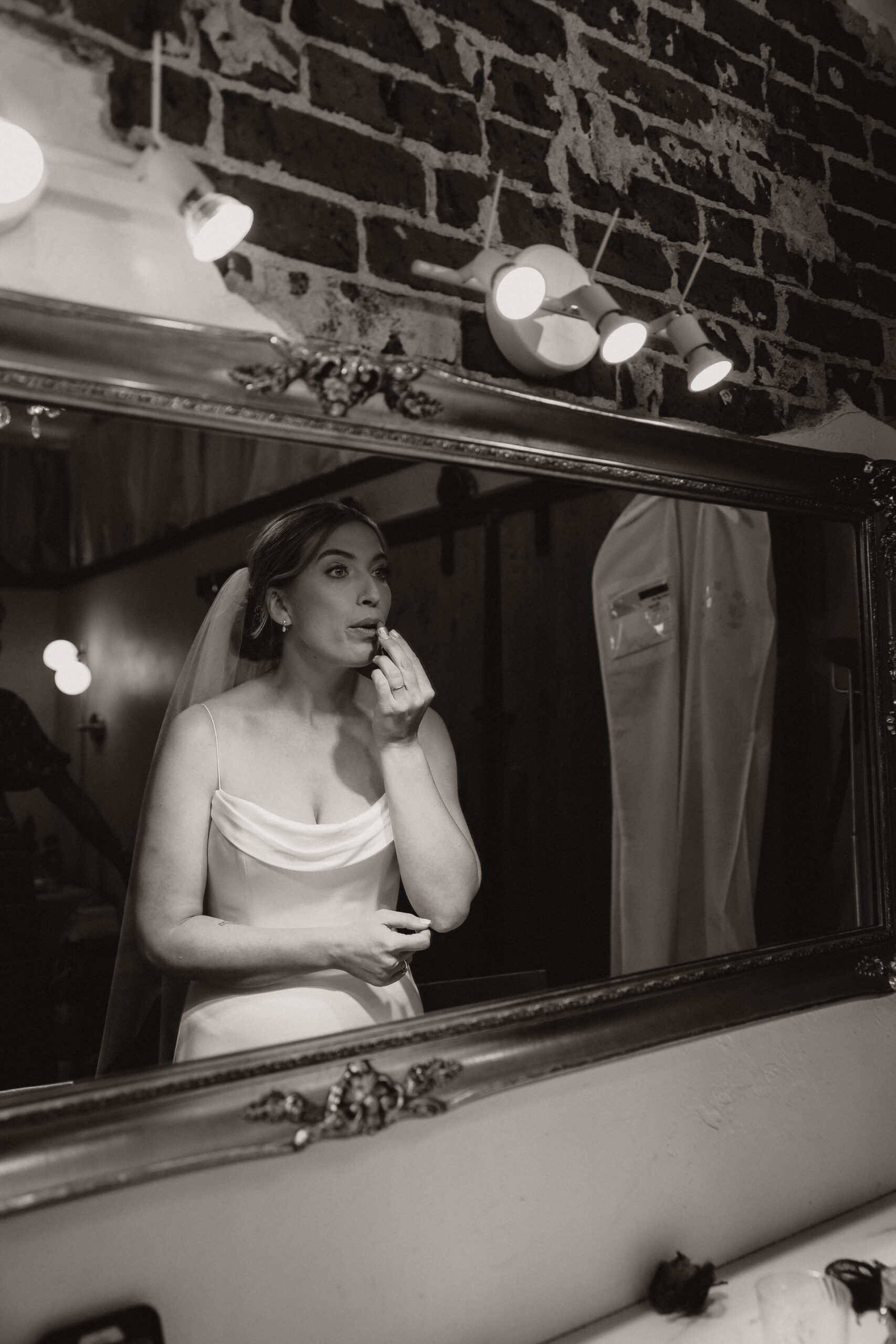 bride looking in the mirror while she gets ready at one of the most perfect Denver Colorado venues