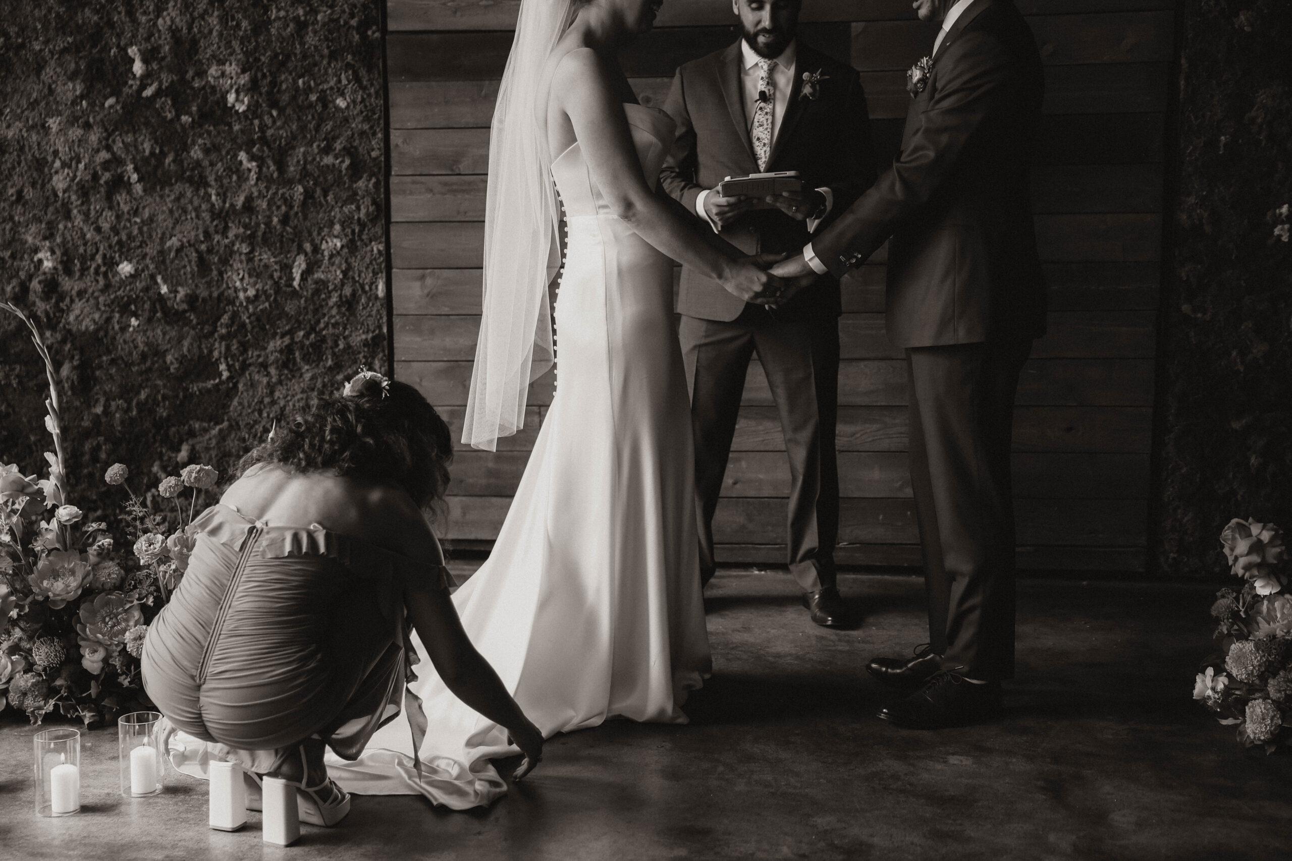 bride getting help with her dress at the altar 