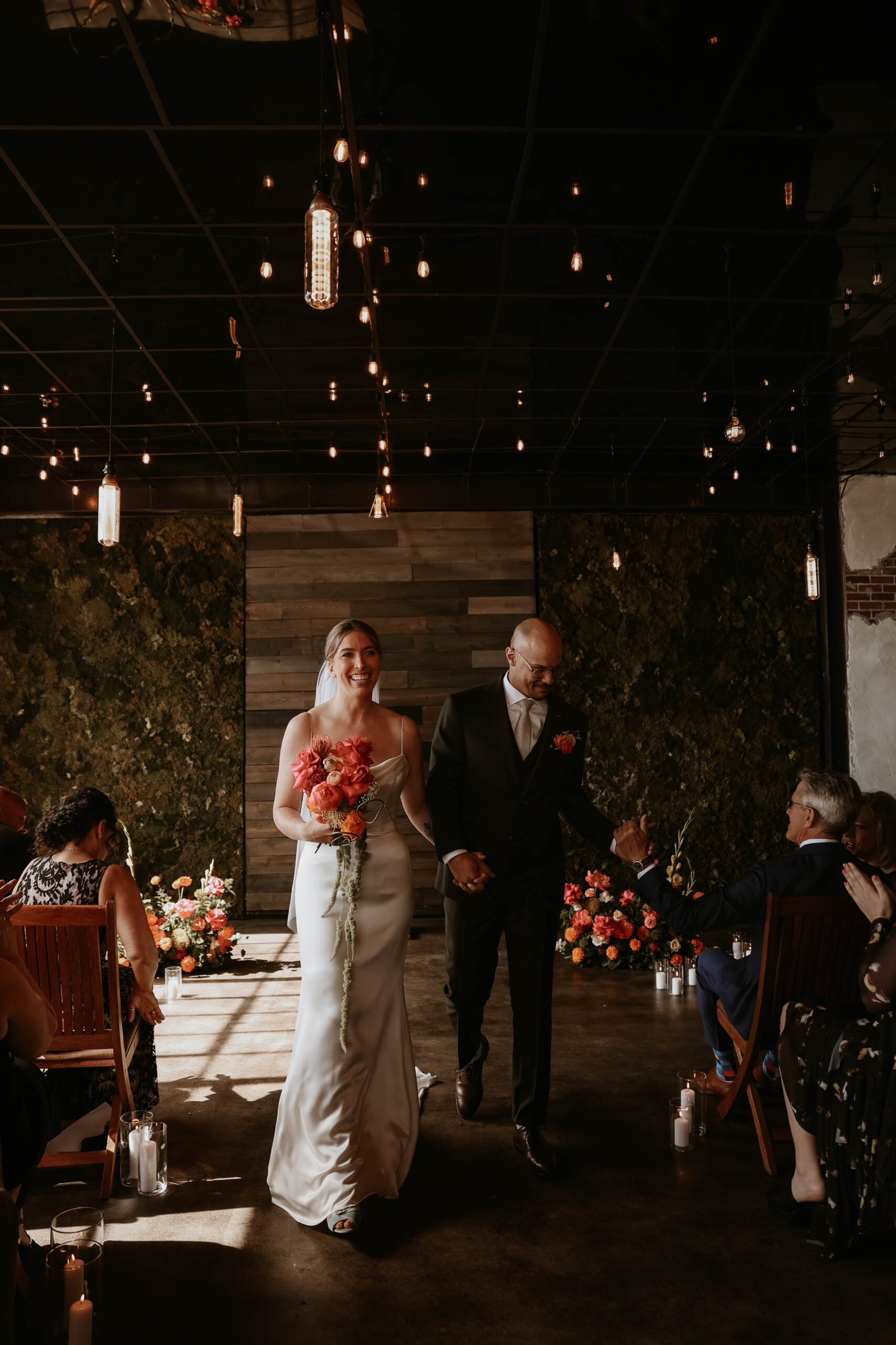 bride and groom smiling as they walk down the aisle at one of the most perfect Denver Colorado venues