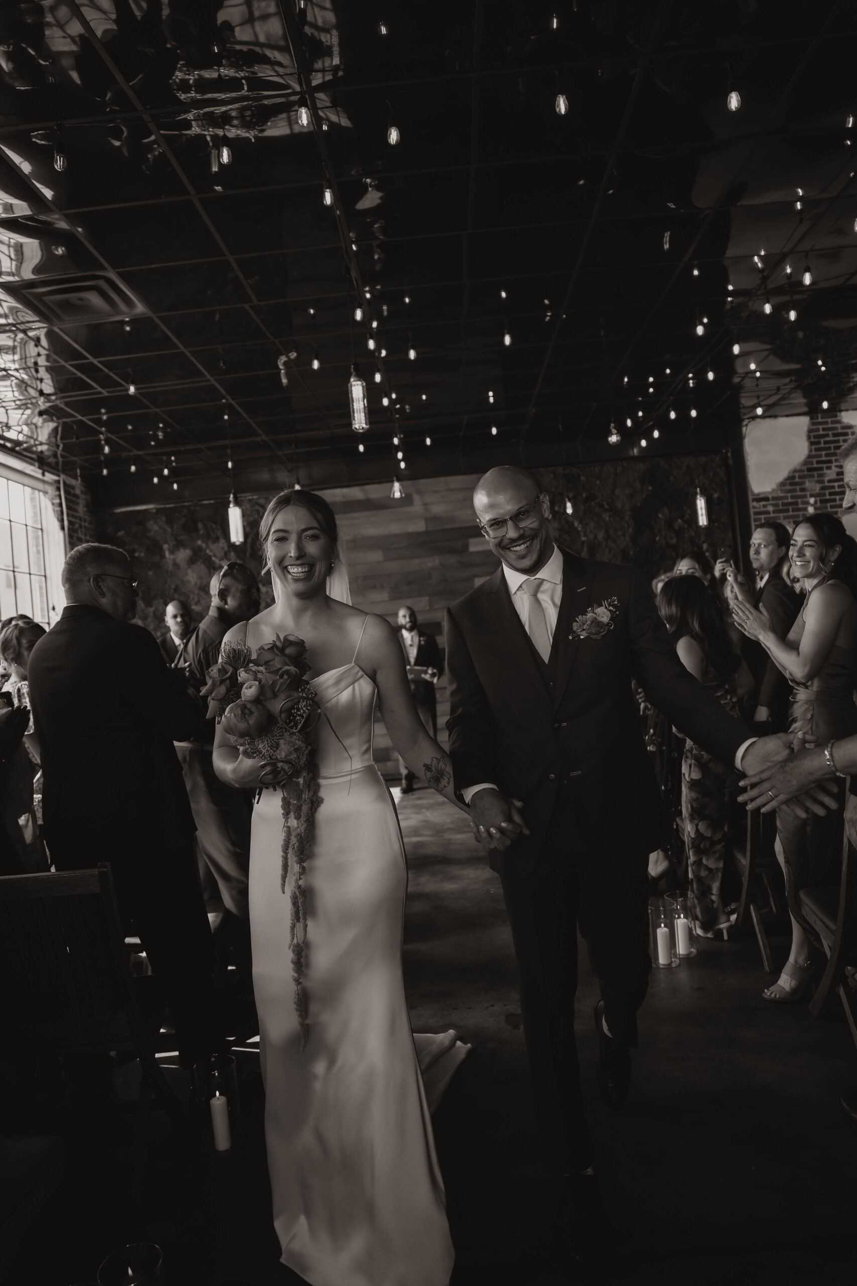 bride and groom laughing as they walk down the aisle 