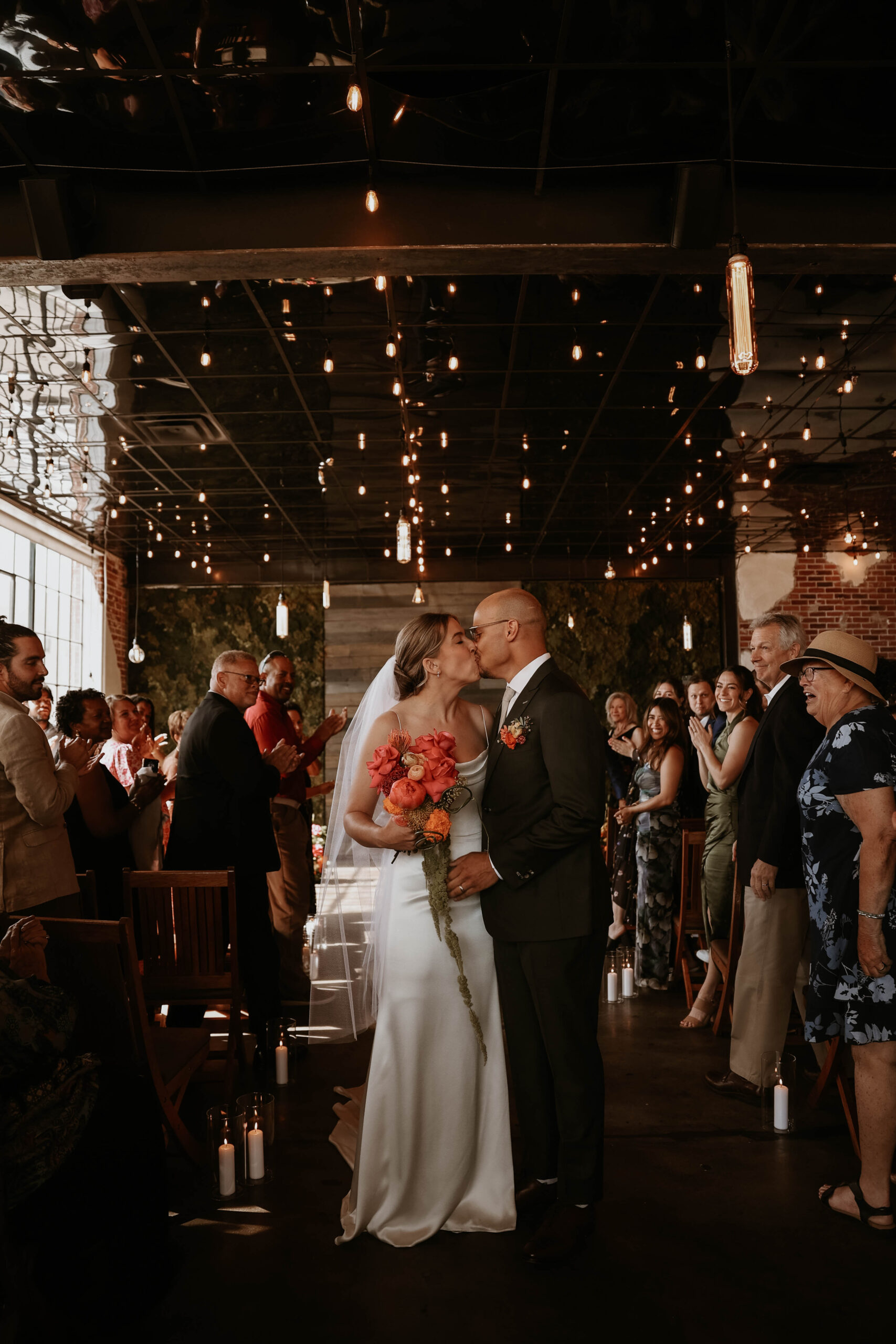 bride and groom kissing at the end of the aisle 