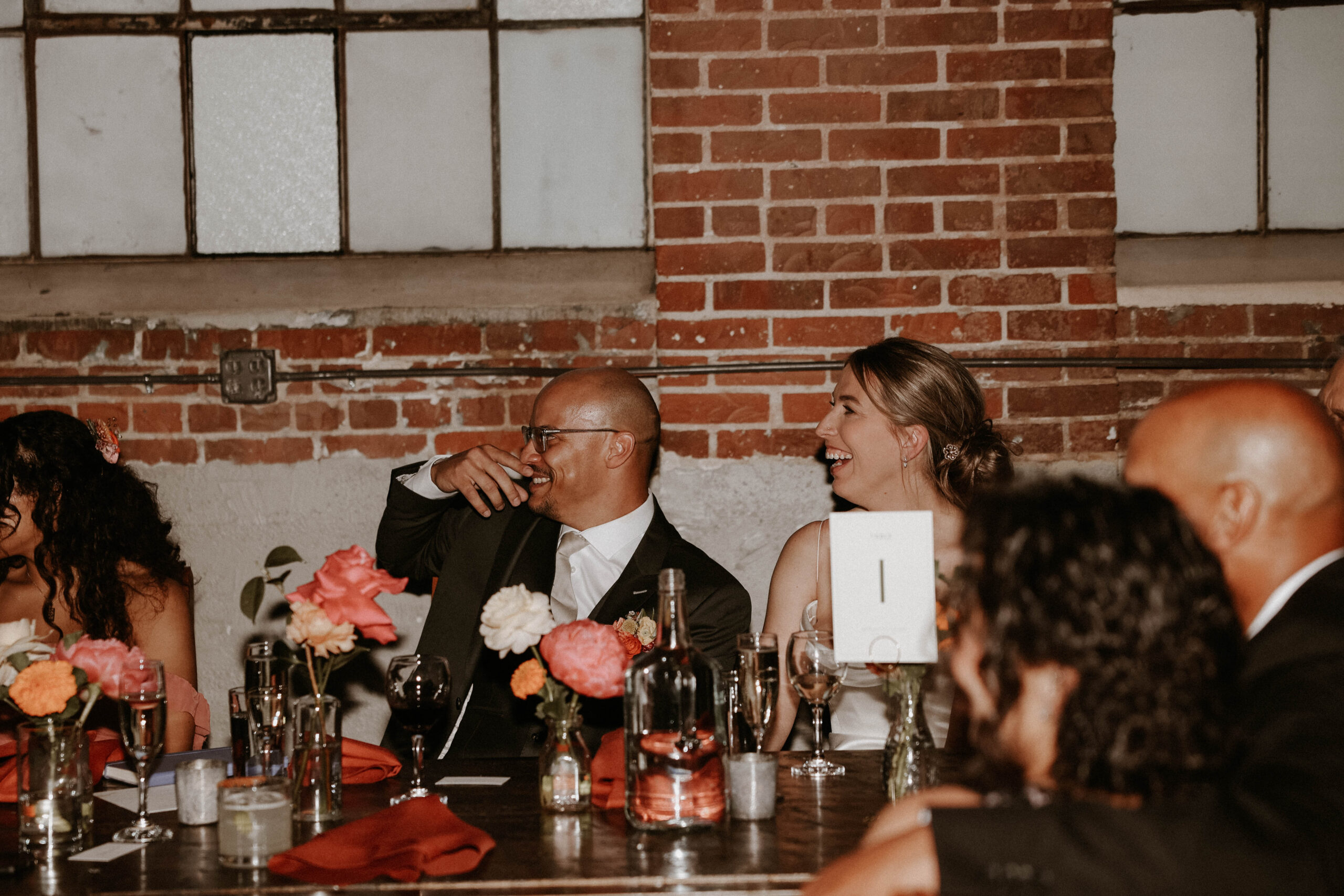 bride and groom laughing at the head table 