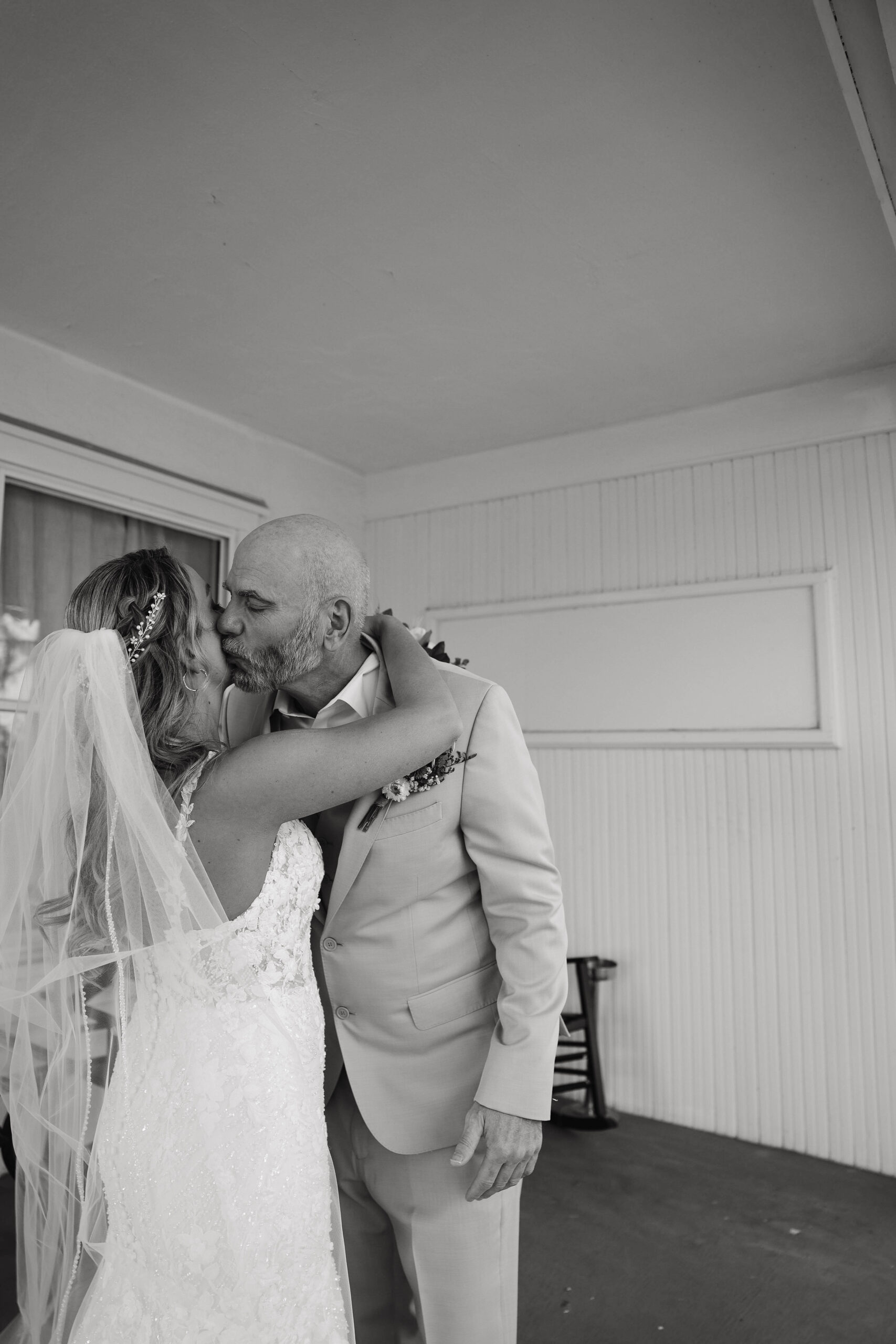 dad giving daughter a kiss on the cheek 