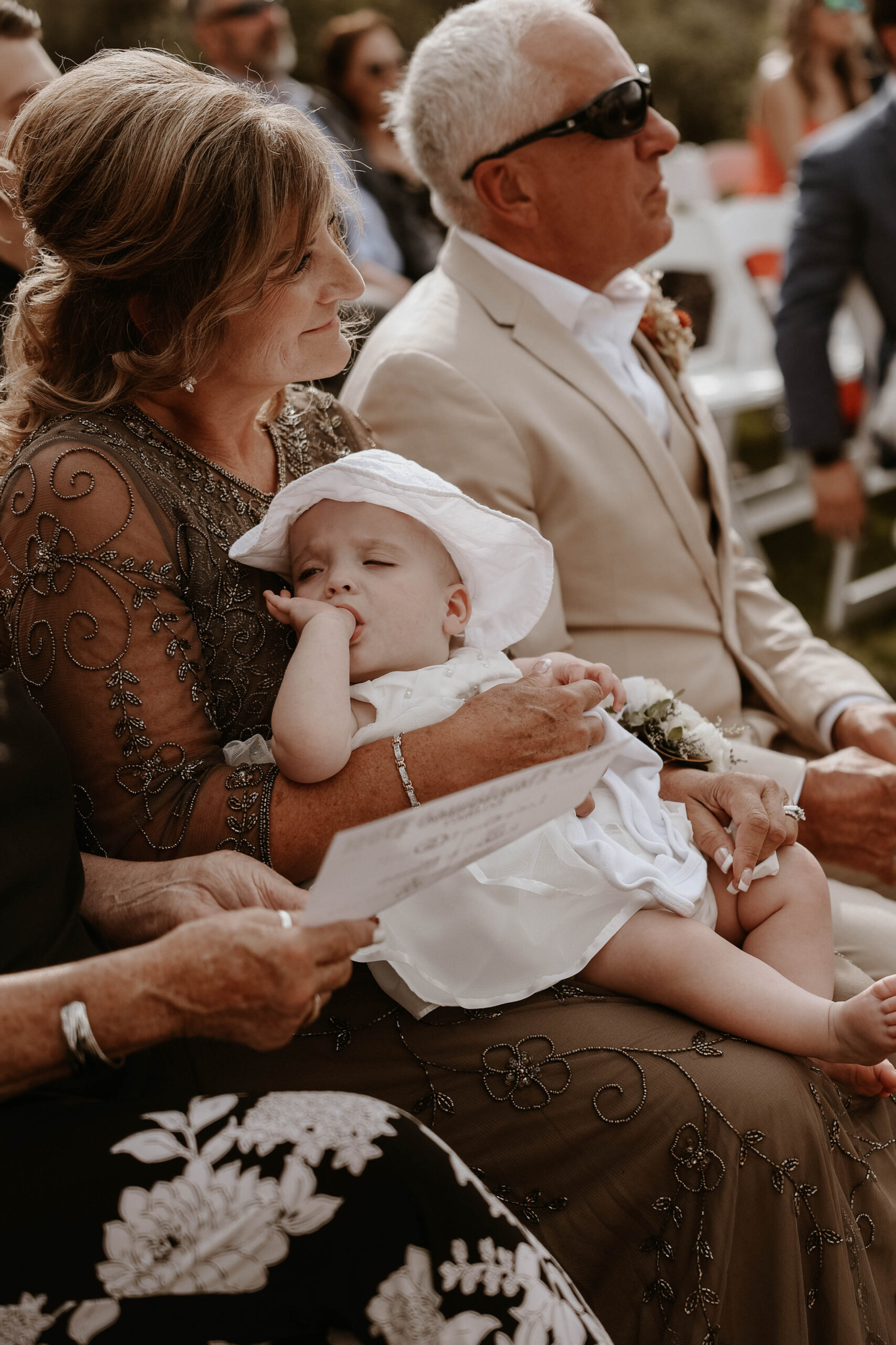 baby girl sitting on grandma's lap during manor house wedding ceremony 