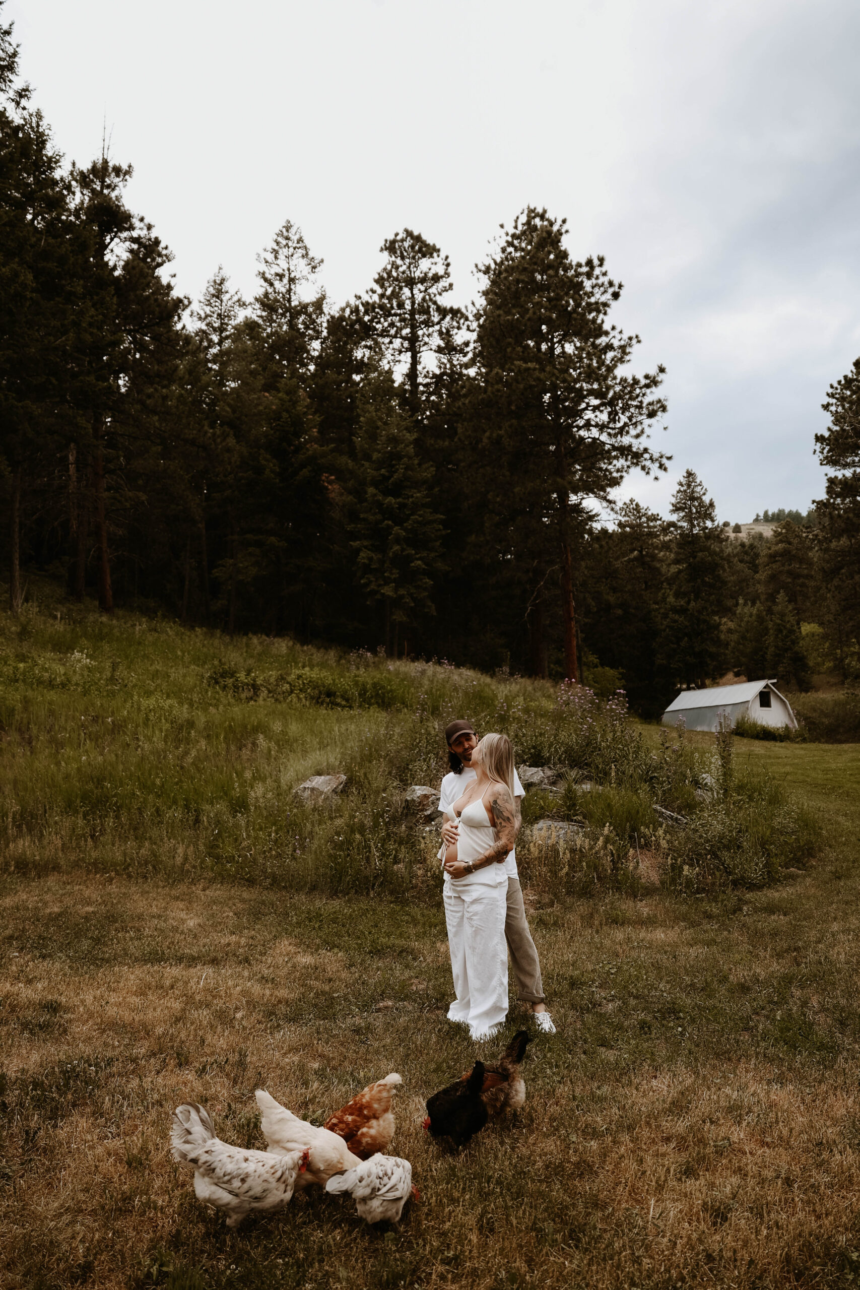 a couple standing together with their chickens during a Denver Maternity Photography session 