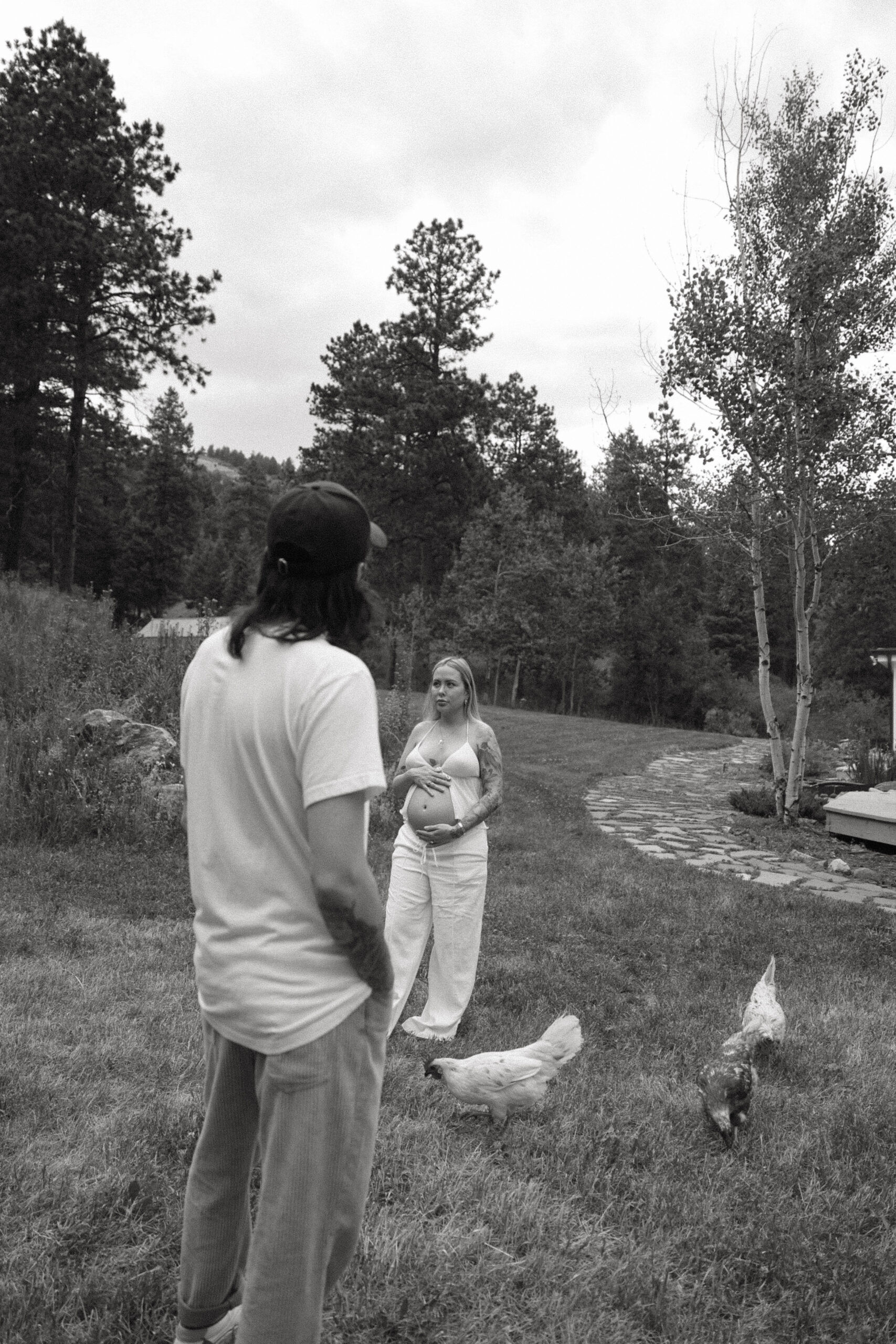 a couple in their backyard with their chickens during a Denver Maternity Photography session 