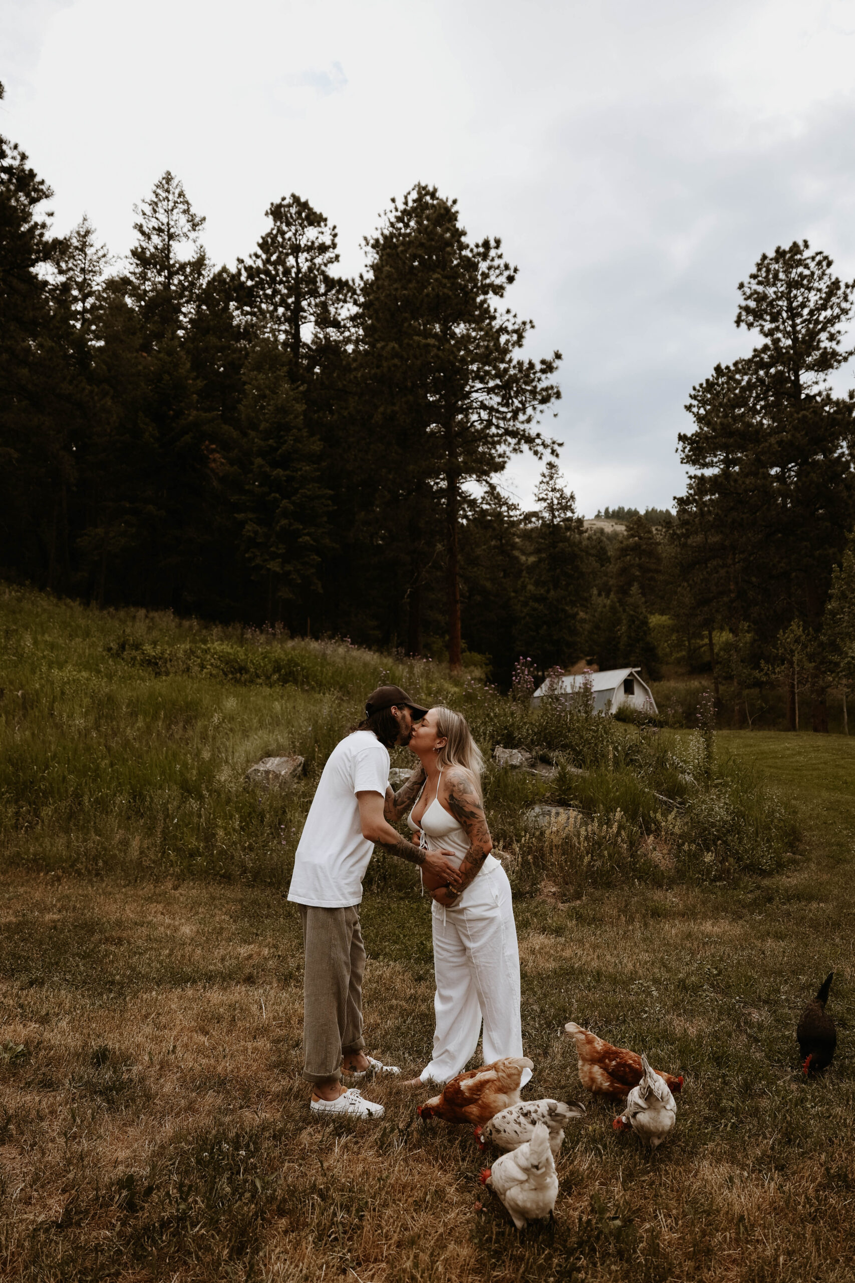 a couple kissing in their back yard during a Denver Maternity Photography session 