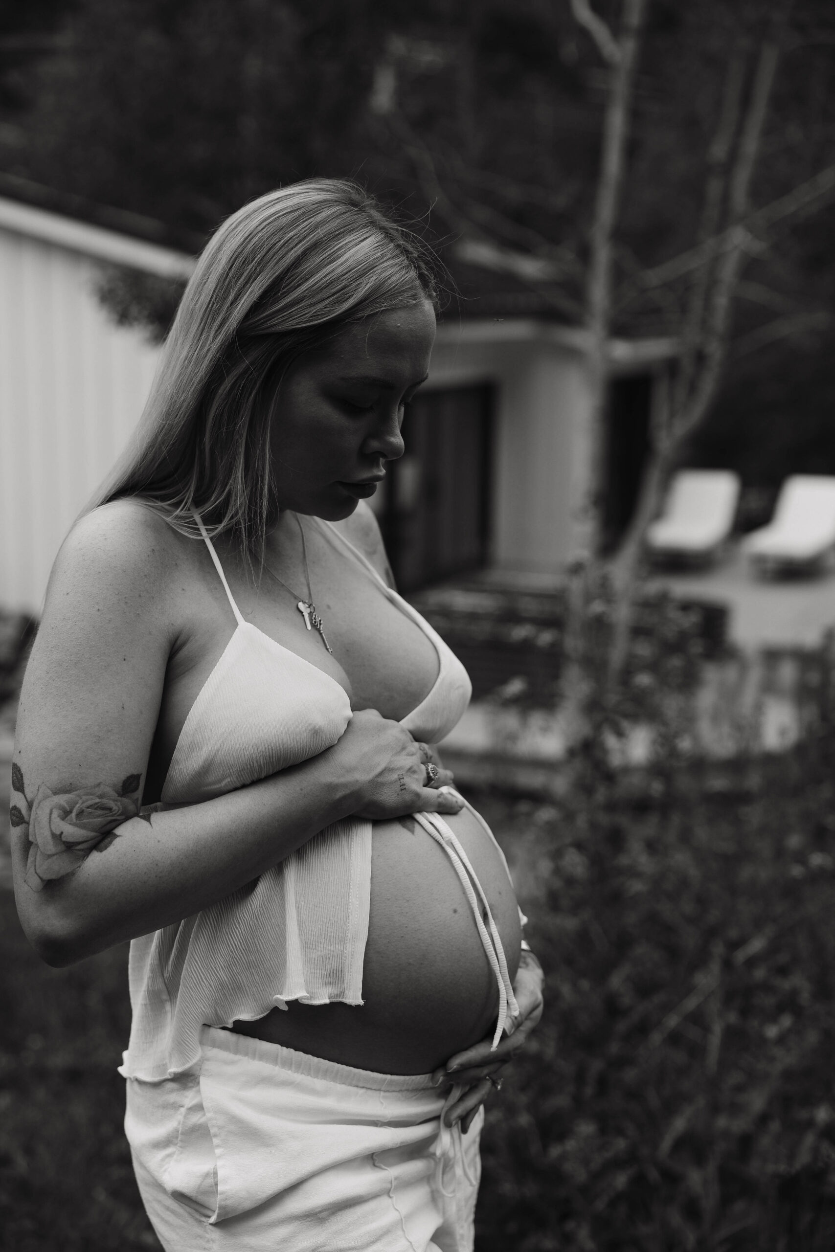 a pregnant woman holding her stomach during her home maternity photoshoot