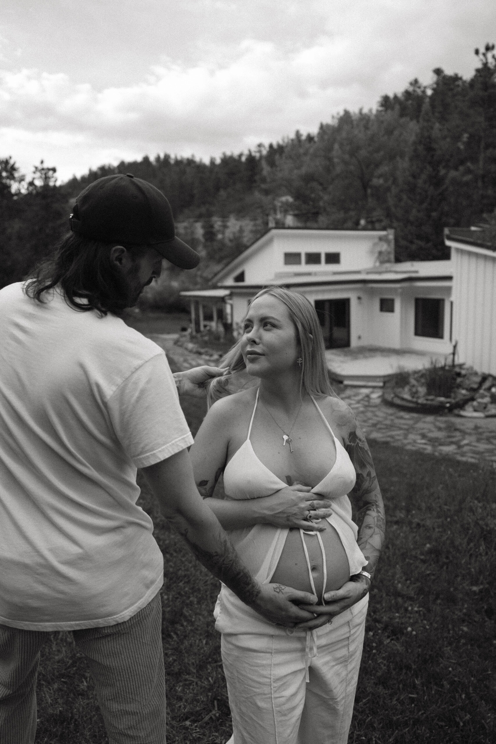 a man holding a pregnant woman's stomach during a Denver Maternity Photography session 