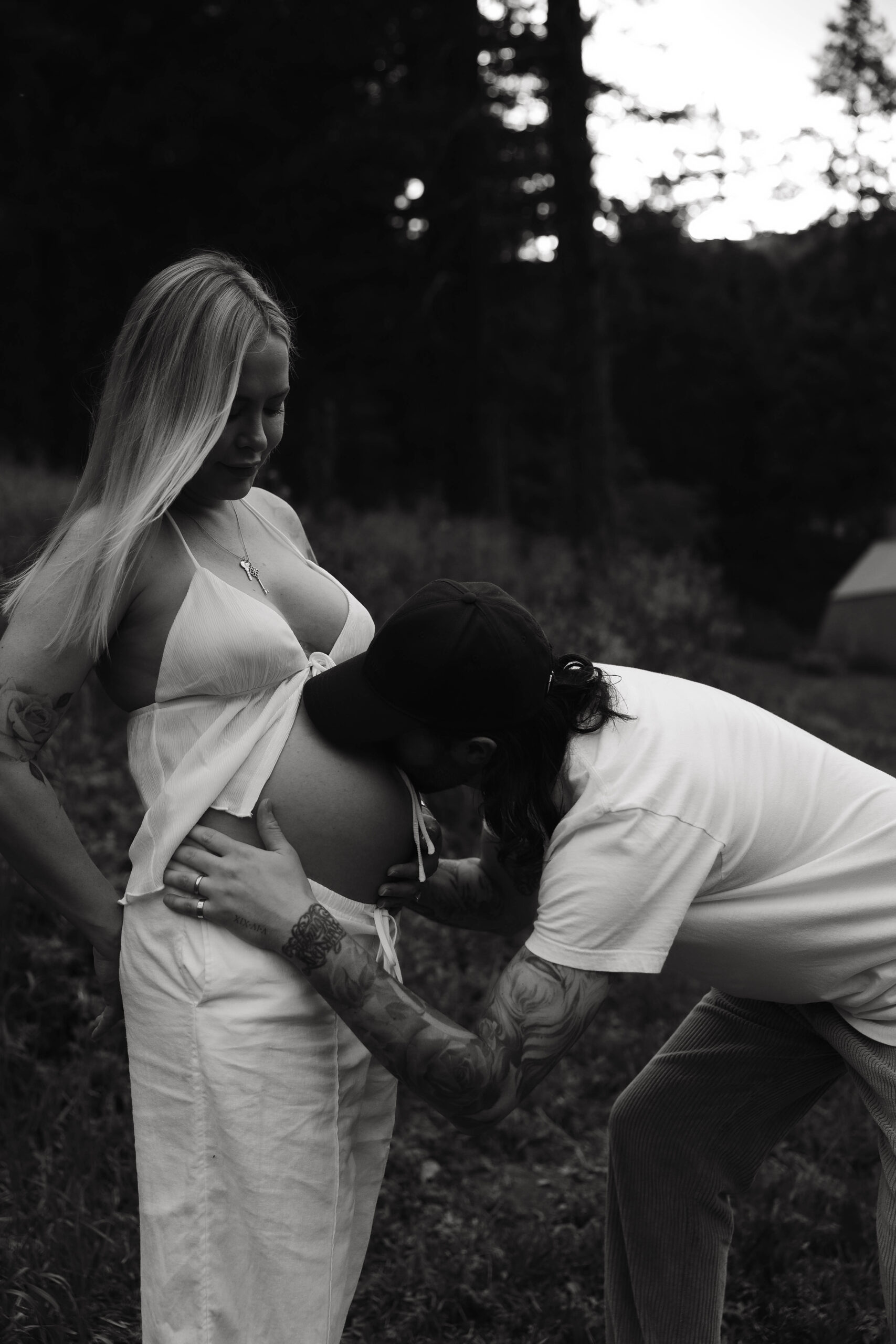 a man kissing a pregnant woman's stomach during a Denver Maternity Photography session 