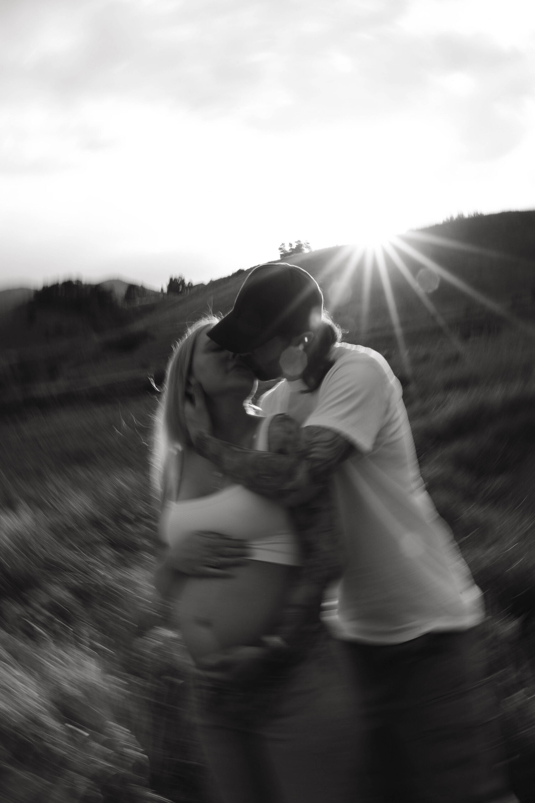 a blurry photo of a man kissing a pregnant woman 