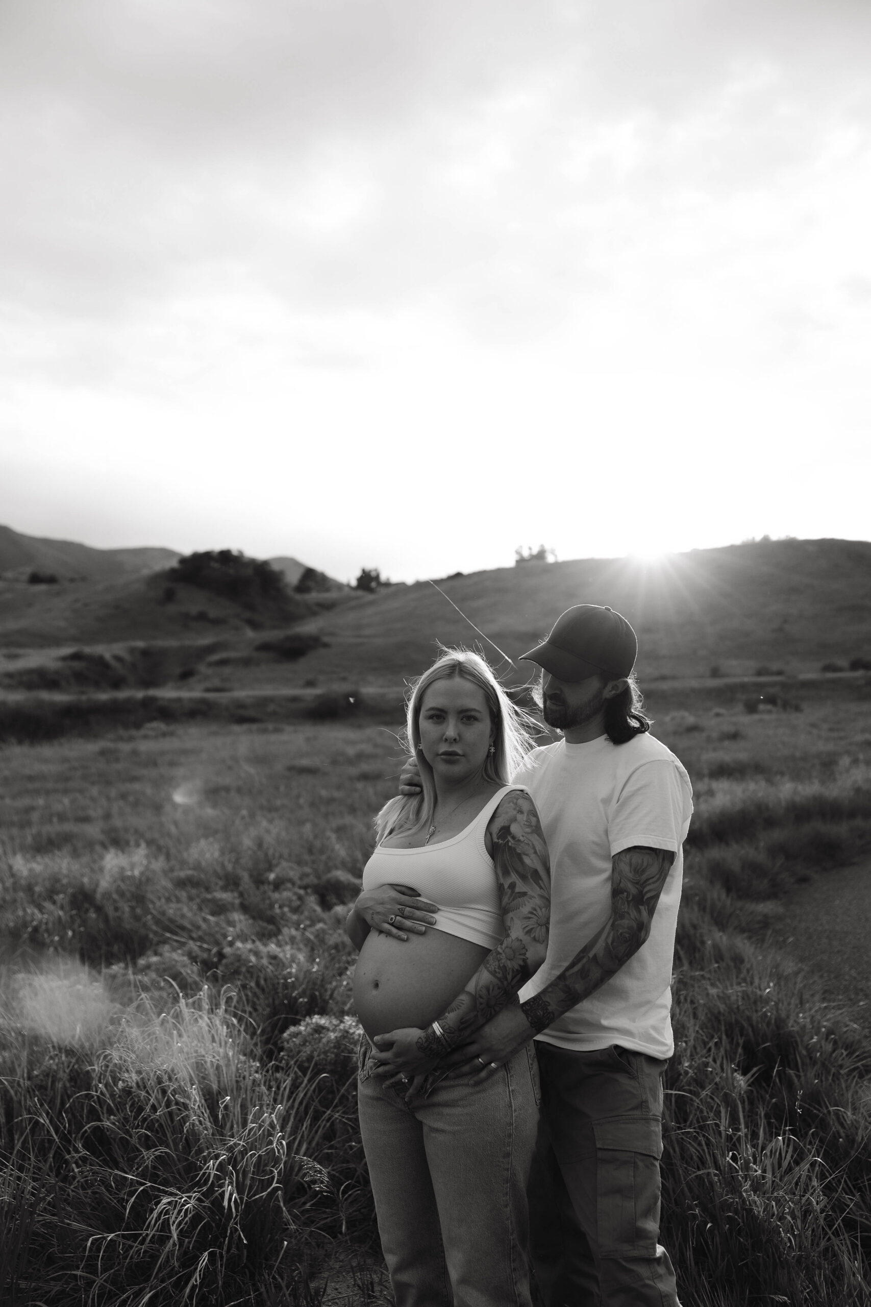 a couple holding each other in a field during a Denver Maternity Photography session 