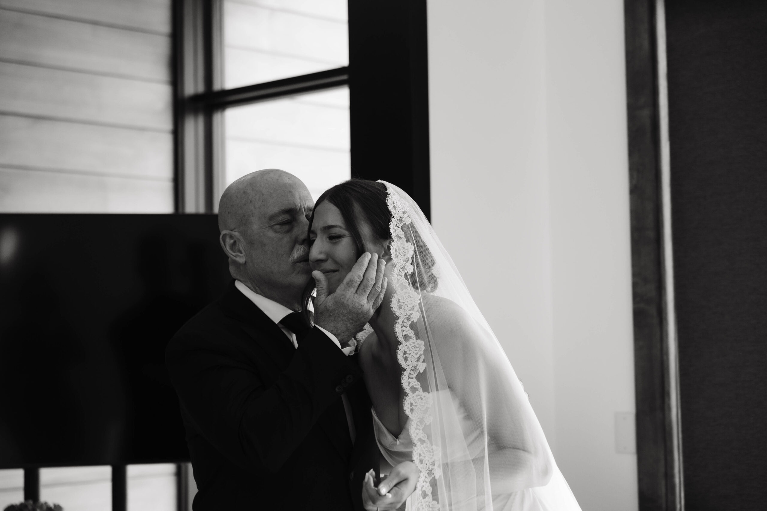 dad kissing daughter on the cheek