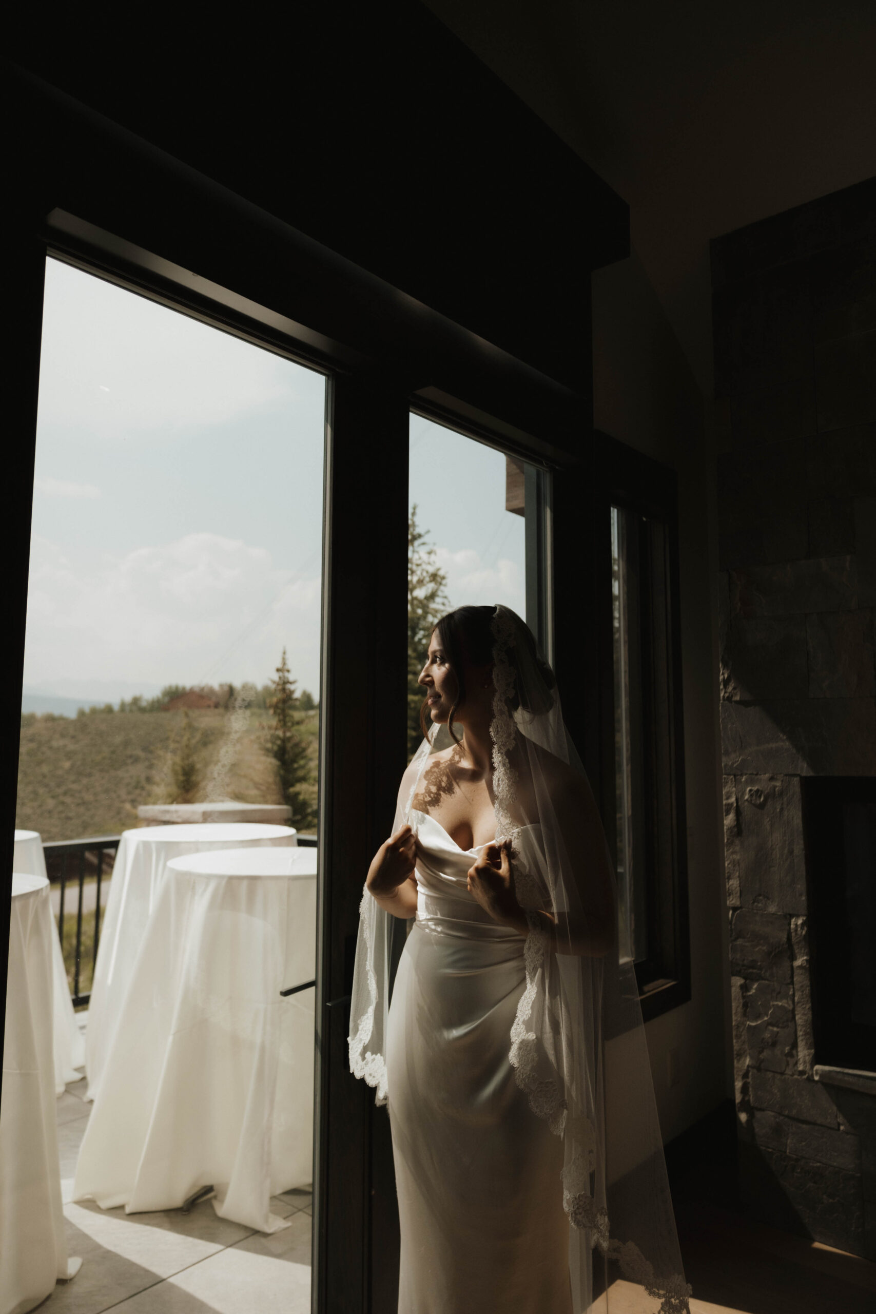 bride standing by the window at a Colorado micro wedding