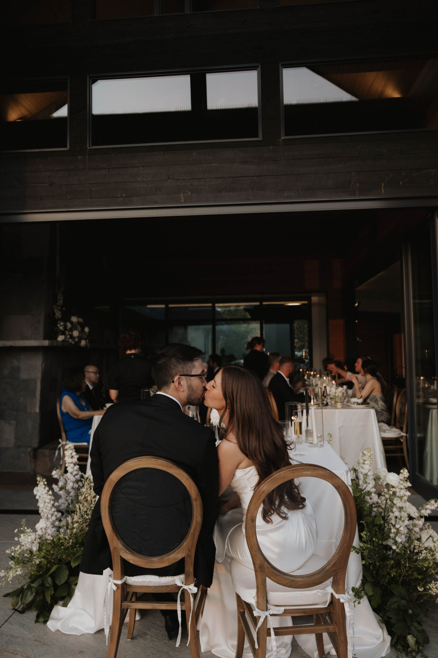 bride and groom kissing at their head table 