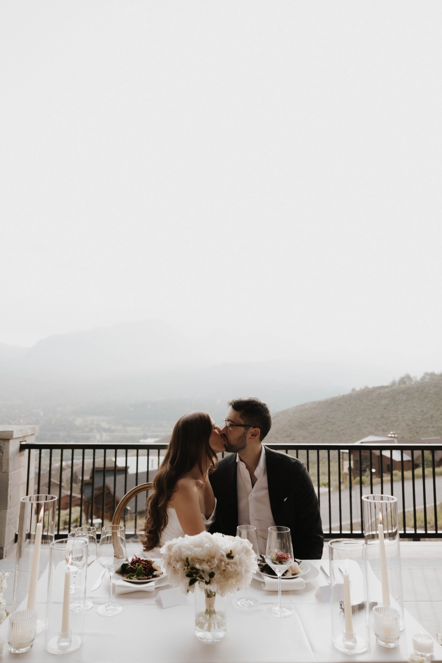 bride and groom kissing at their head table 