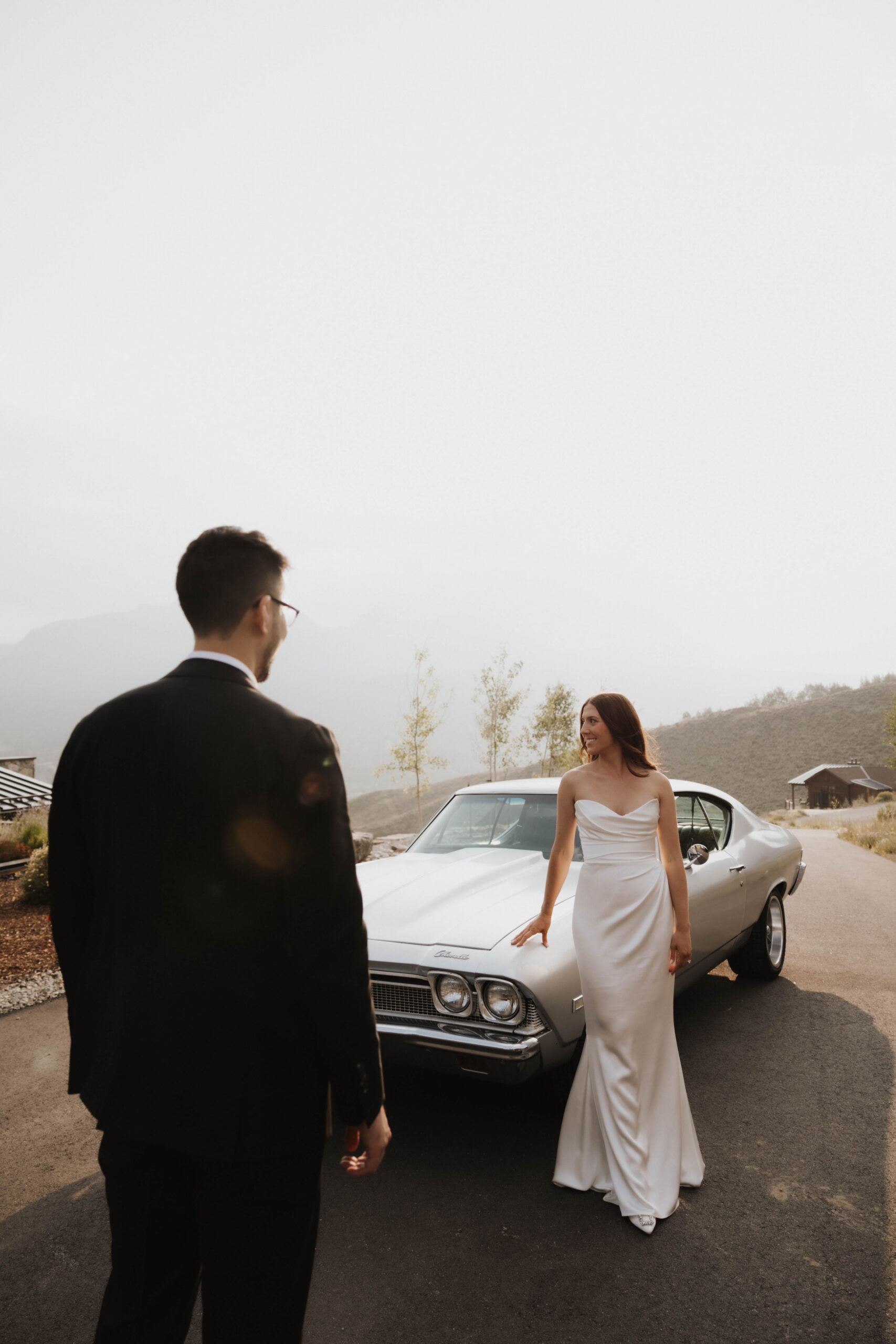 bride and groom portrait in front of a vintage car at their Colorado micro wedding