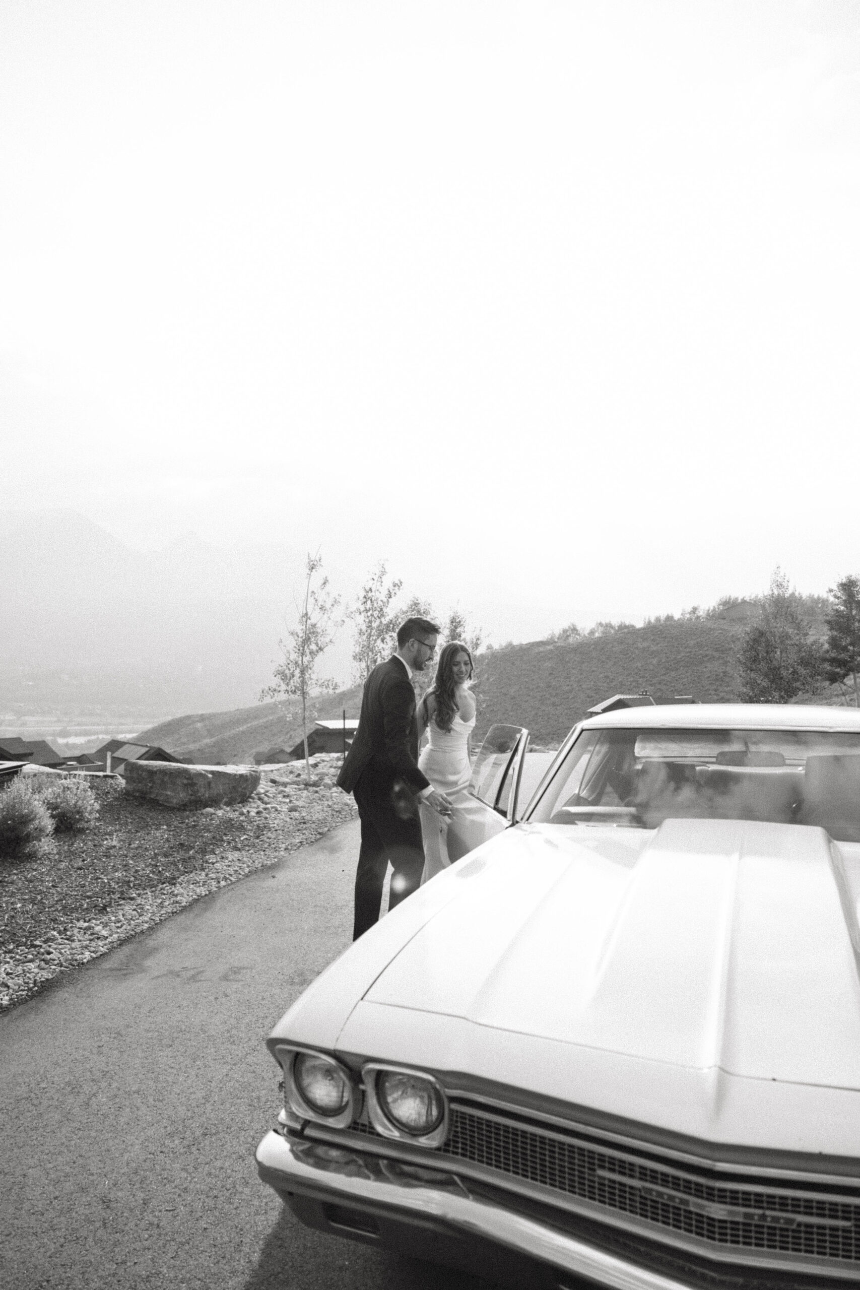 bride and groom getting into a vintage car 