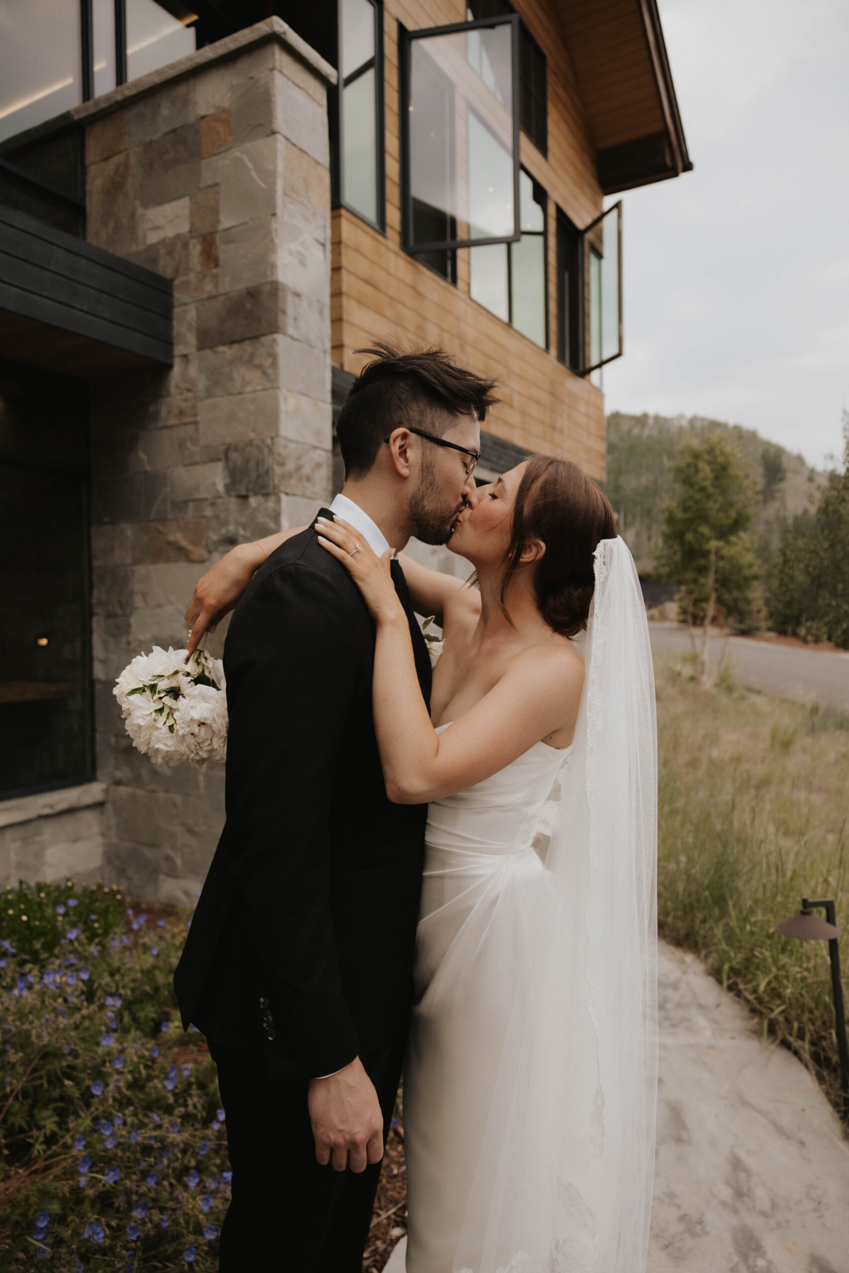 bride and groom kissing in front of the airbnb