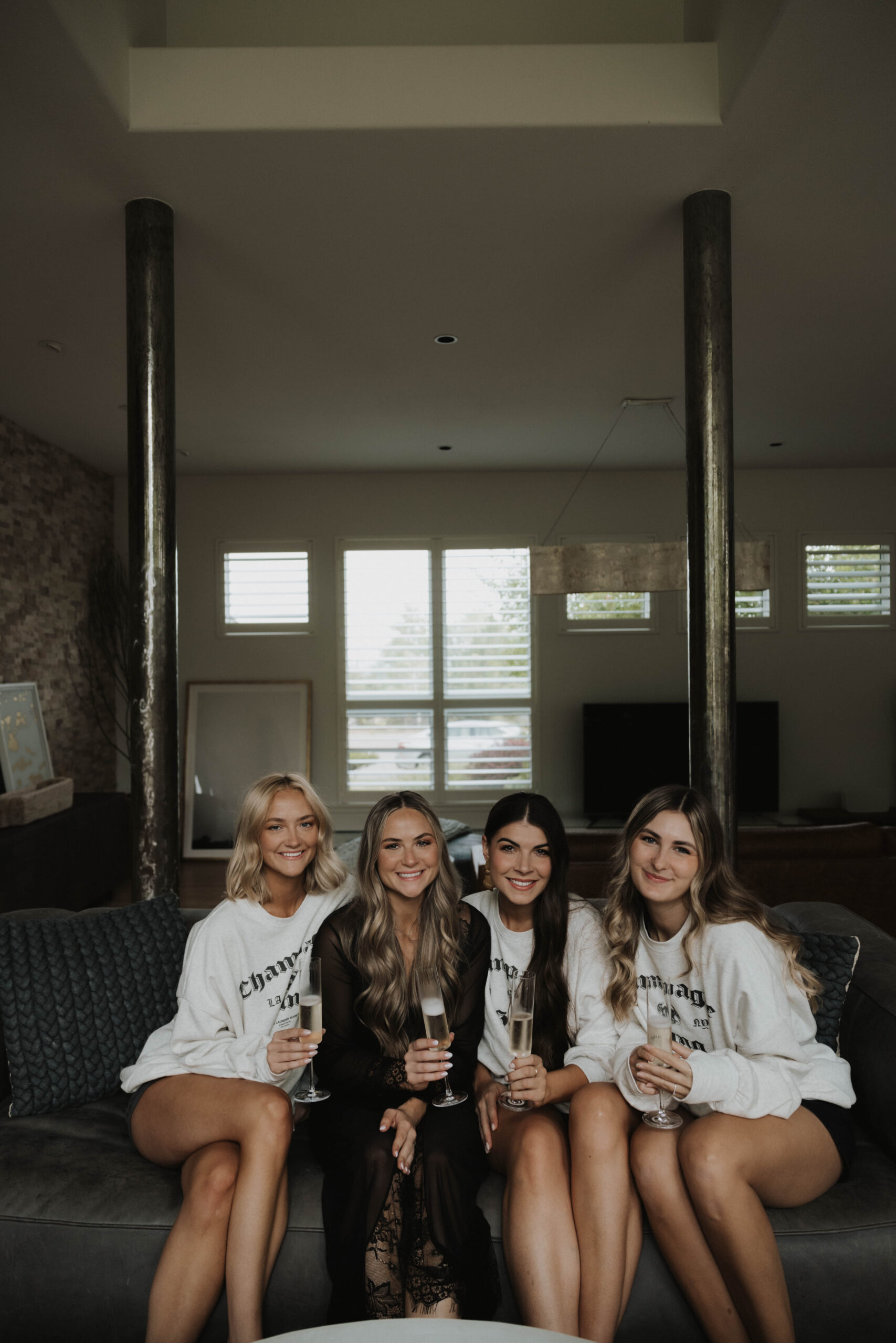 bride and bridesmaids getting ready with champagne 