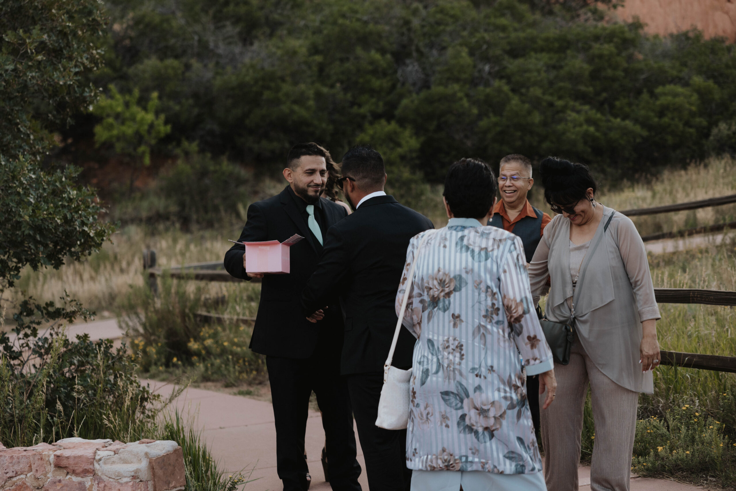 groom greeting guests as they arrive for wedding at garden of the gods