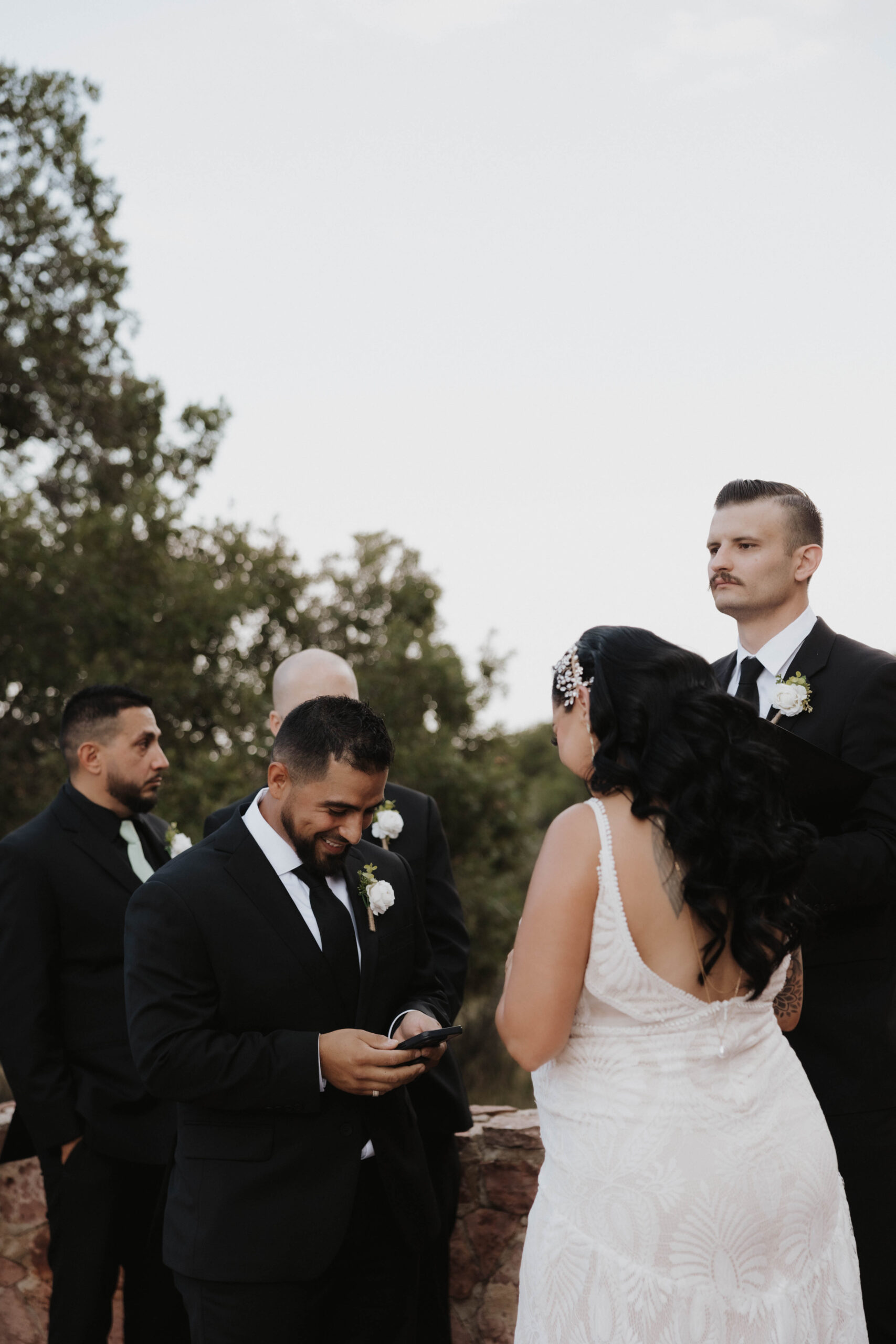 groom smiling as he reads his vows during wedding at garden of the gods