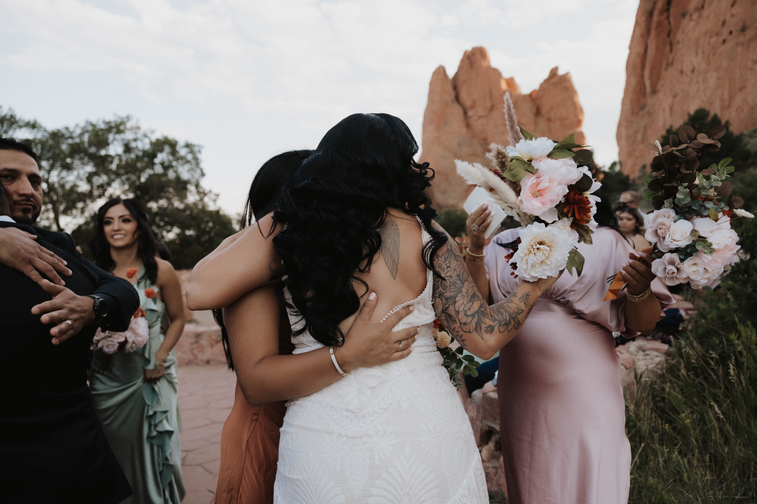 bride hugging her bridesmaids after wedding at garden of the gods