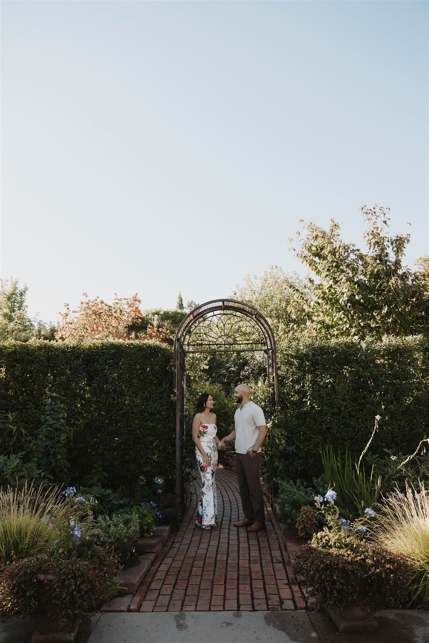 a couple under a trellis at their Denver Botanic Gardens Engagement Photos session